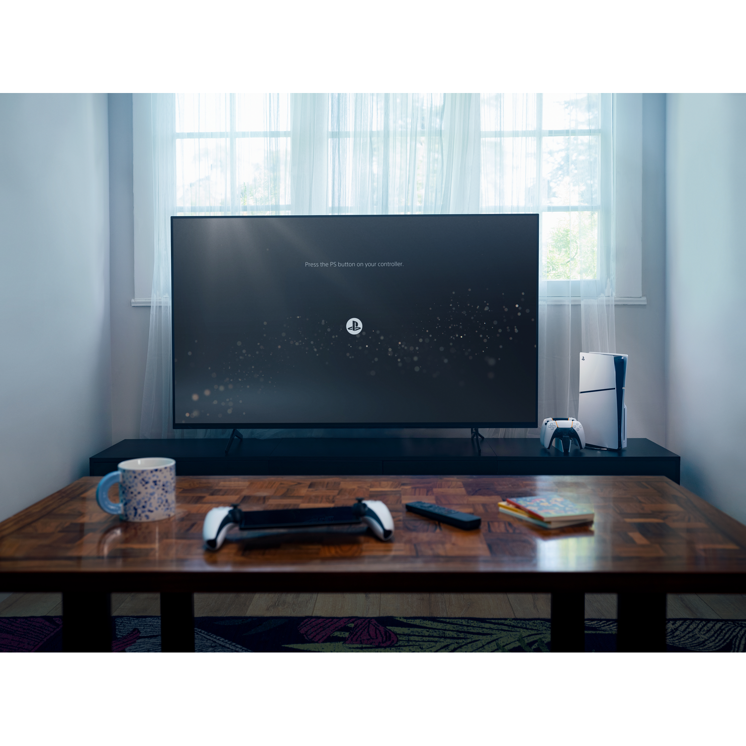 A gaming setup with a TV, console, and controllers on a wooden table.