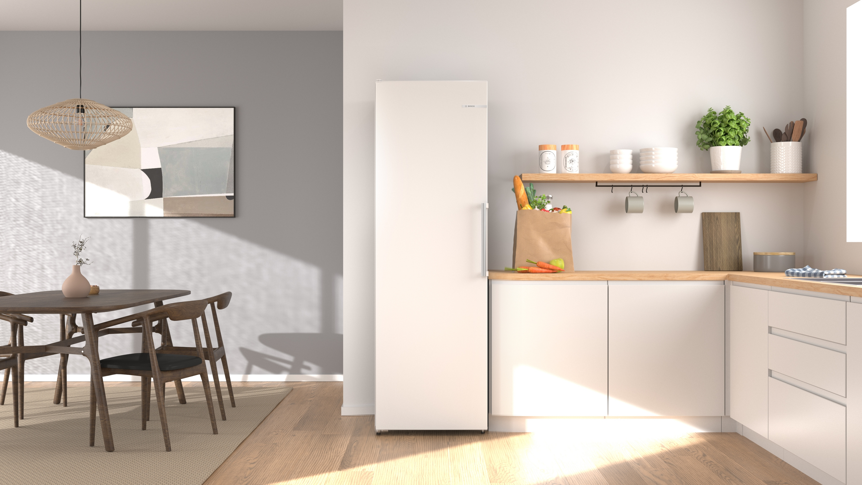 Modern kitchen with a white fridge, wooden dining table, chairs, and abstract art.
