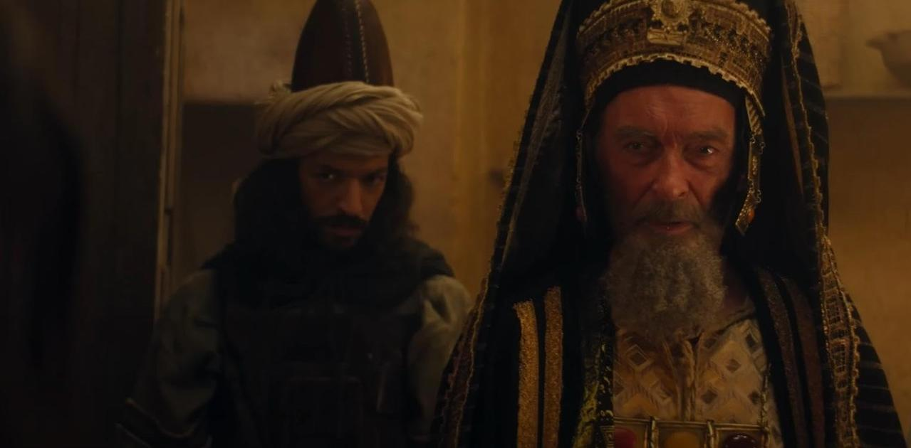 Ein Mann mit Bart trägt eine verzierte Kopfbedeckung, neben ihm ein Mann mit Turban.