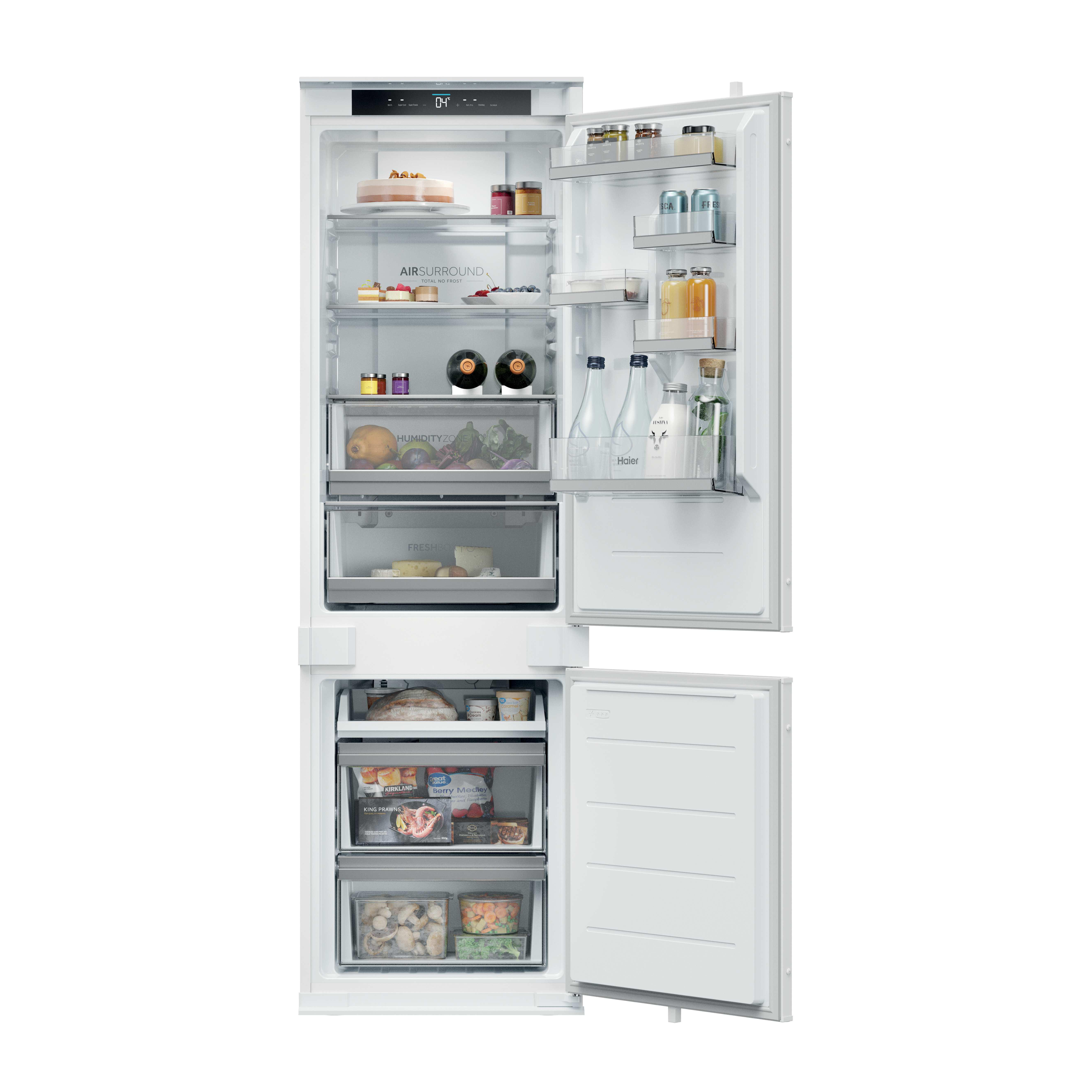 Offener weißer Kühlschrank mit Lebensmitteln: Kuchen, Gläser, Flaschen, Obst, Käse, Brot, Tiefkühlkost.