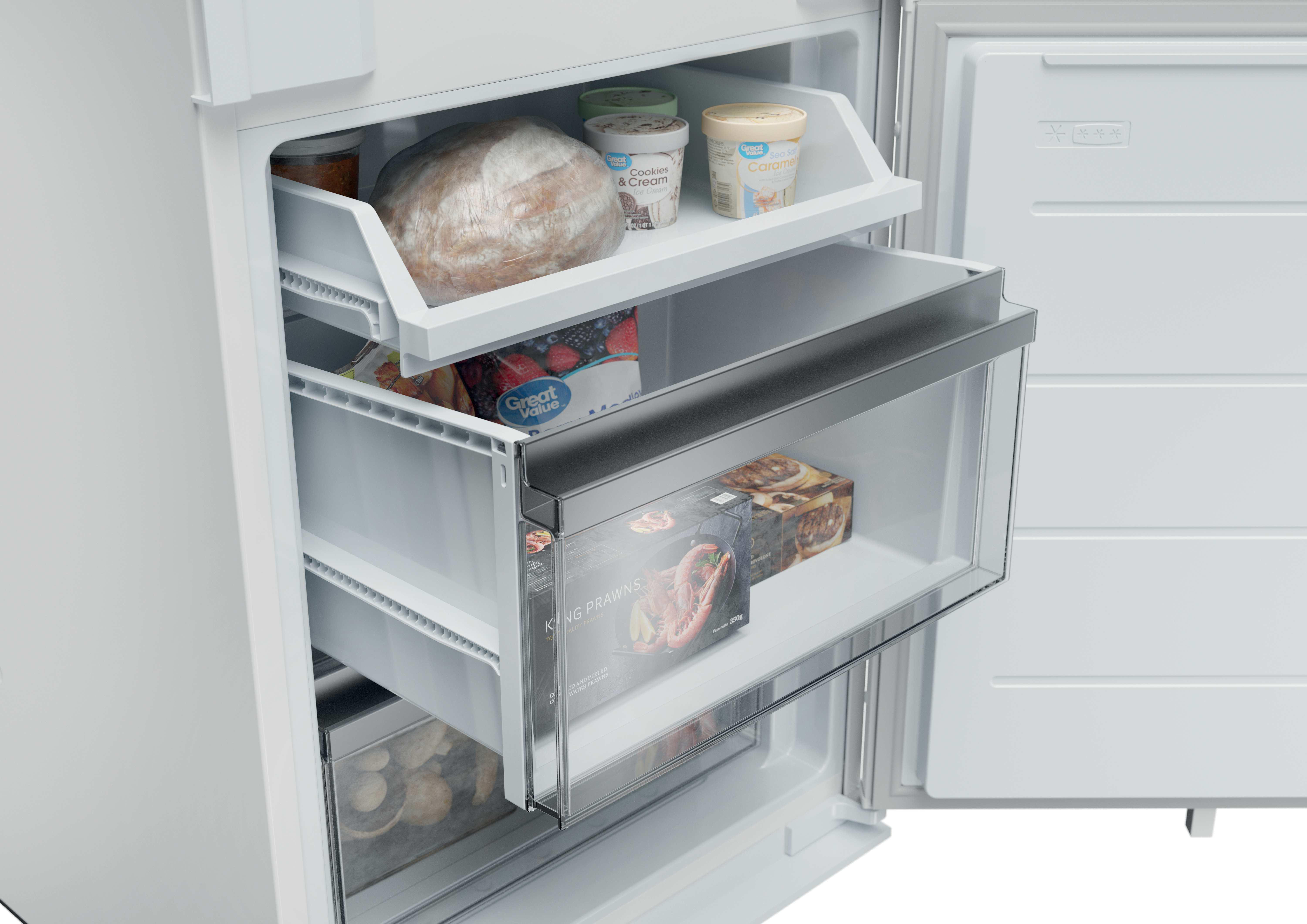 In einem weißen Kühlschrank lagern auf Regalen Brot, Eiscreme, gefrorene Beeren und Garnelen.