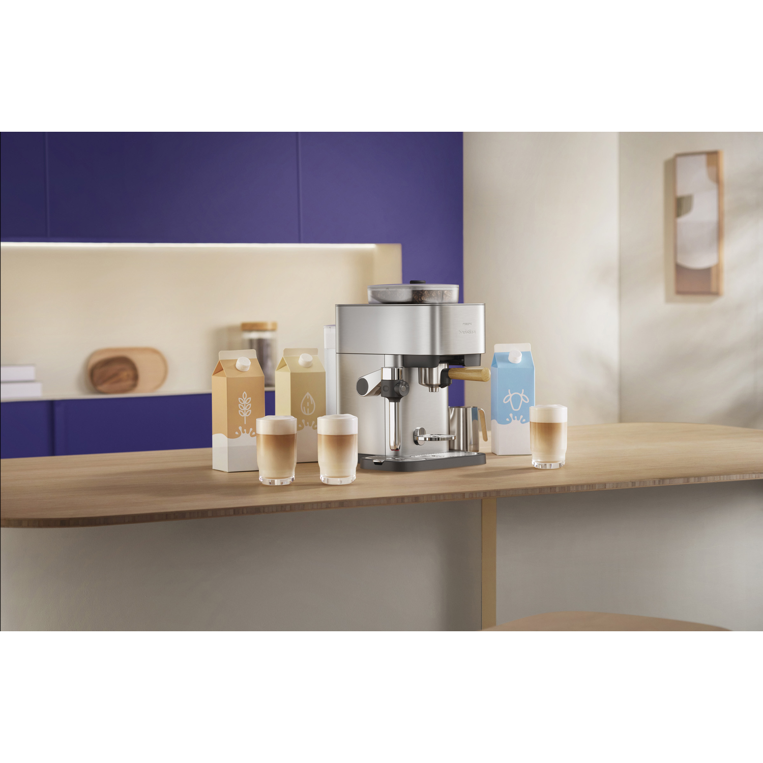 Espressomachine met vier melkpakken en drie latteglazen op een houten tafel.