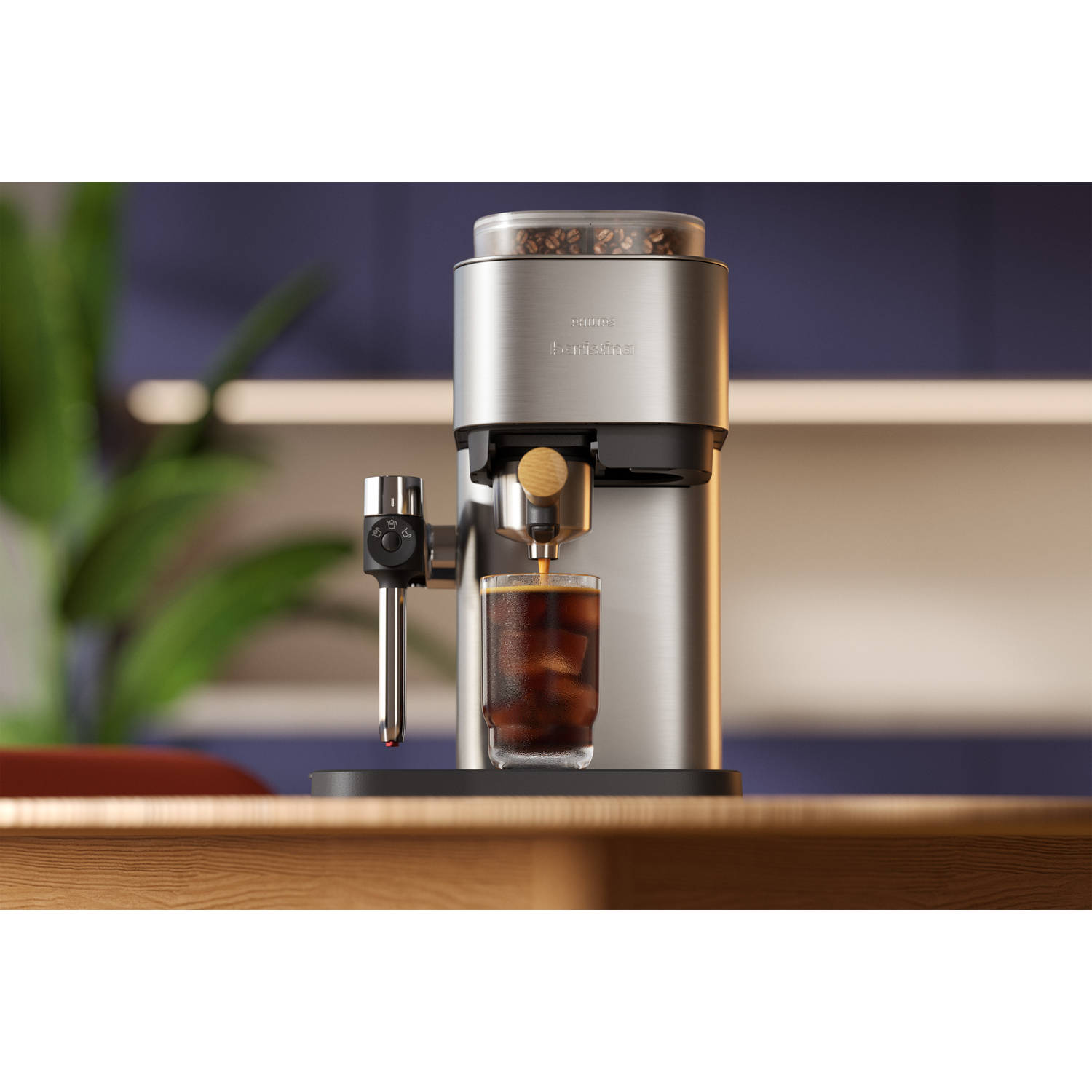 Een zilveren koffiezetapparaat maalt bonen en zet koffie in een glas met ijsblokjes.