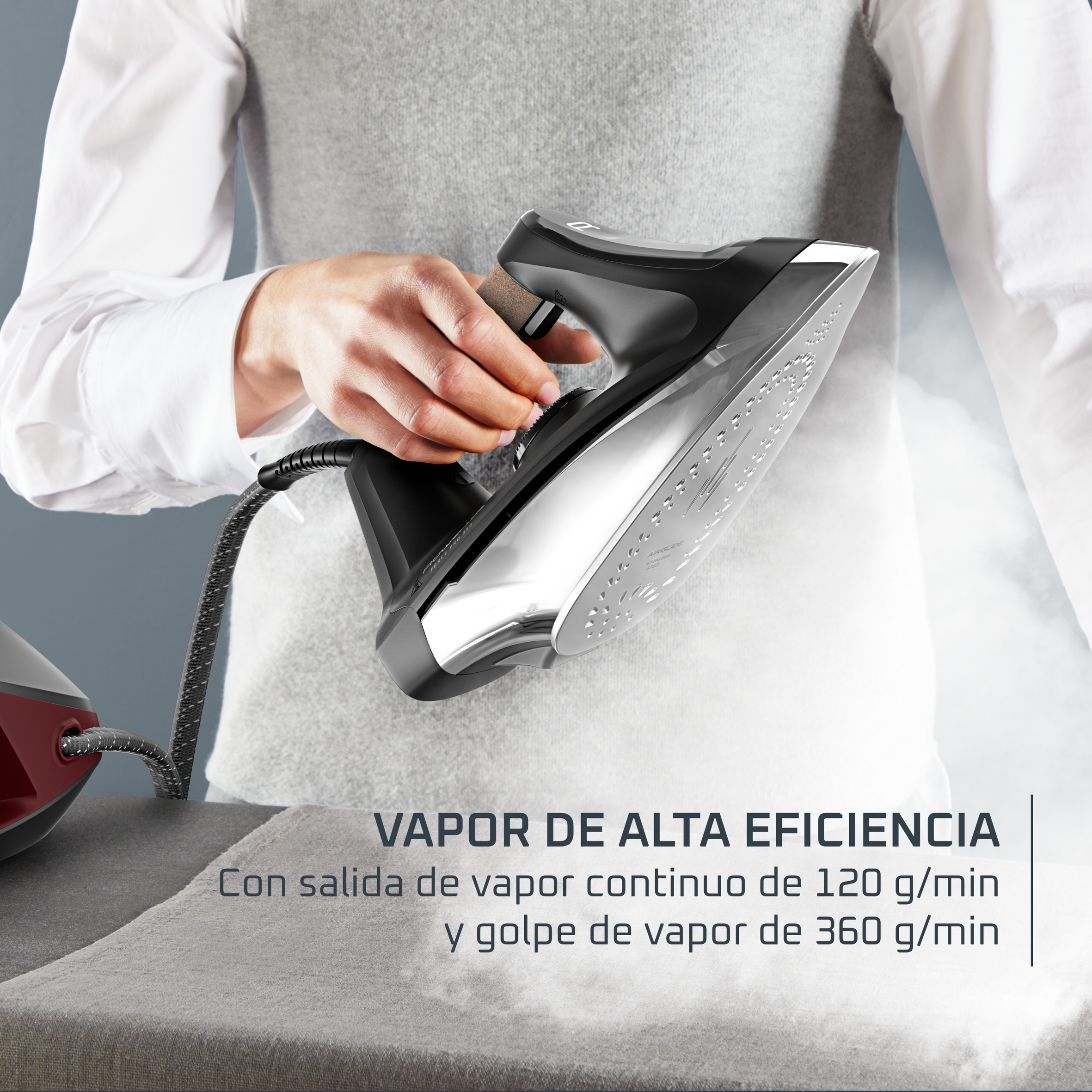 Una mano ajusta una plancha en una tabla de planchar, con vapor saliendo.
