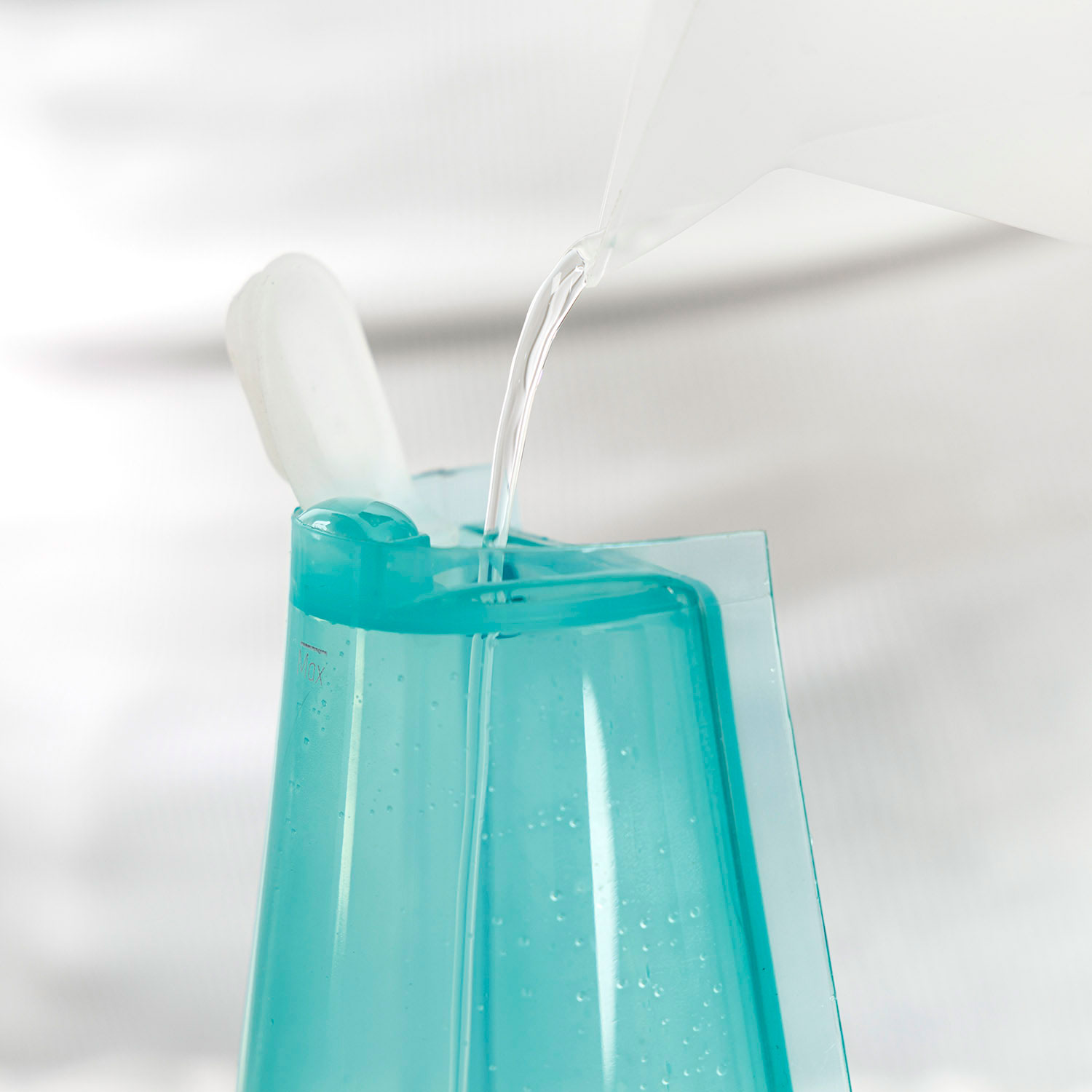 Se vierte agua en un recipiente azul transparente.