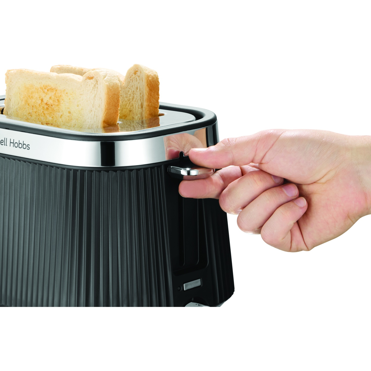 Une main actionne un grille-pain noir avec des tranches de pain.