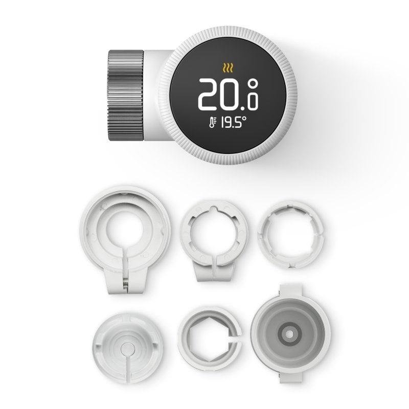 Un termostato digital con dial moleteado y piezas accesorias.