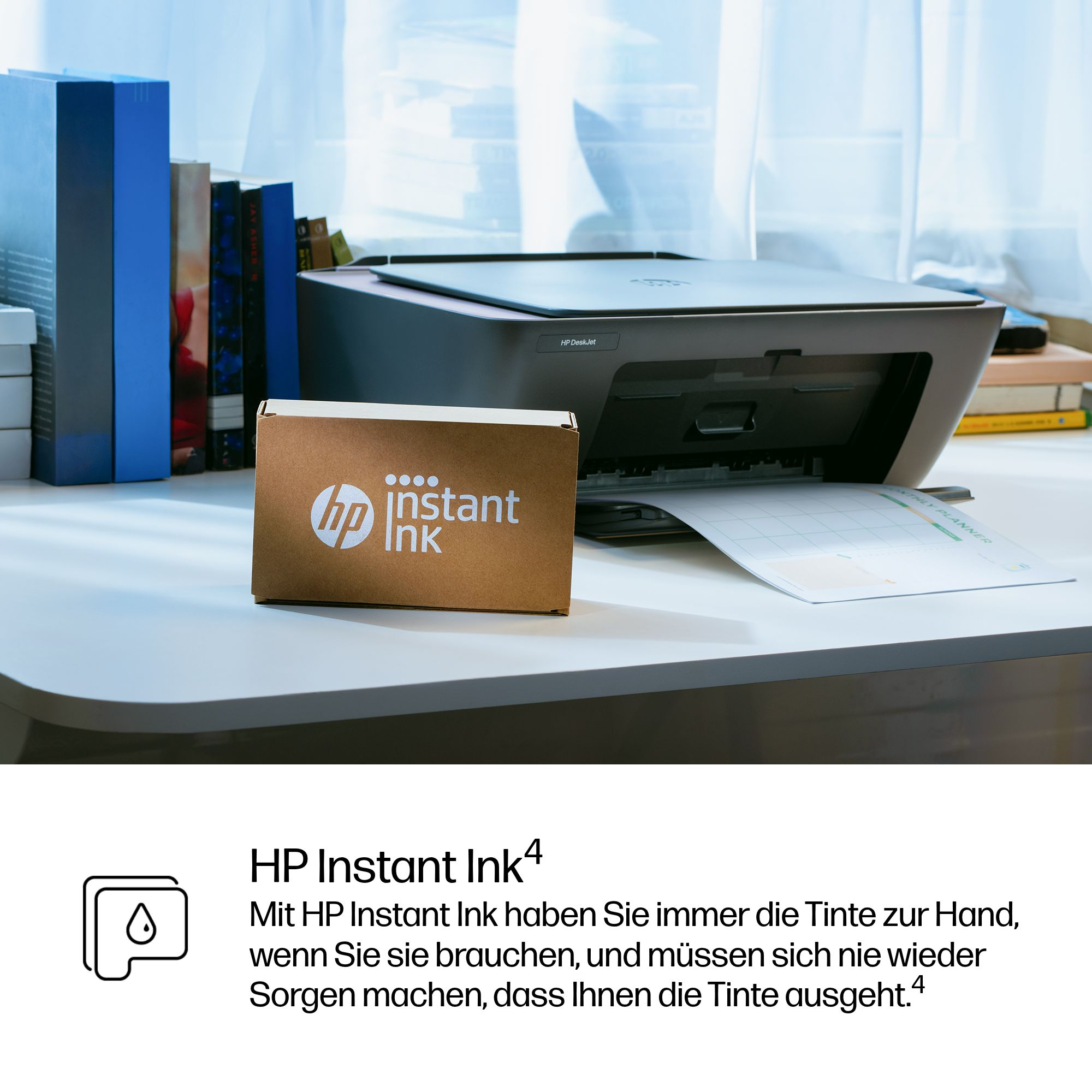 Ein HP Drucker druckt einen Monatsplaner. Daneben steht eine HP Instant Ink Box.