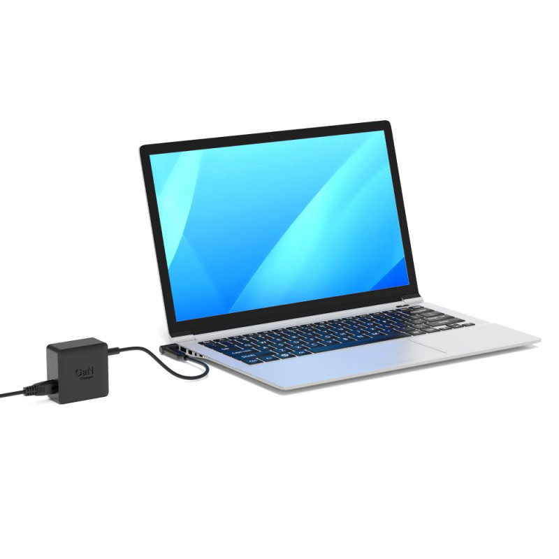 Un laptop argentato con schermo blu è collegato a una presa bianca tramite un caricabatterie nero.