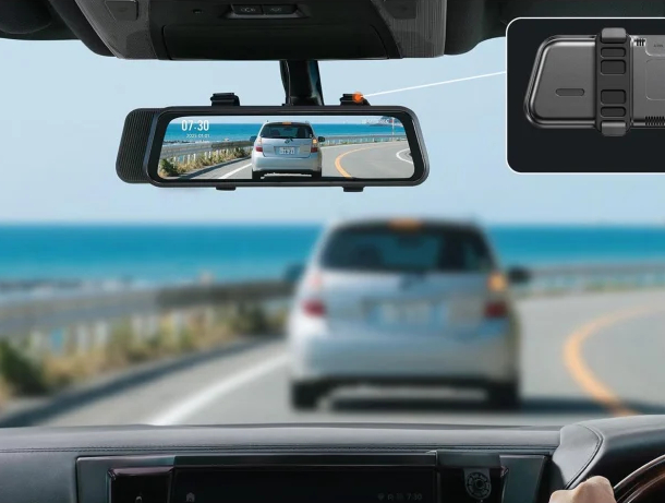 Lusterko wsteczne samochodu pokazuje drogę nad morzem z samochodem przed.