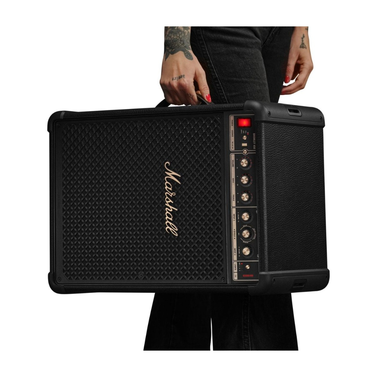 Persona con tatuaggi porta amplificatore Marshall nero.