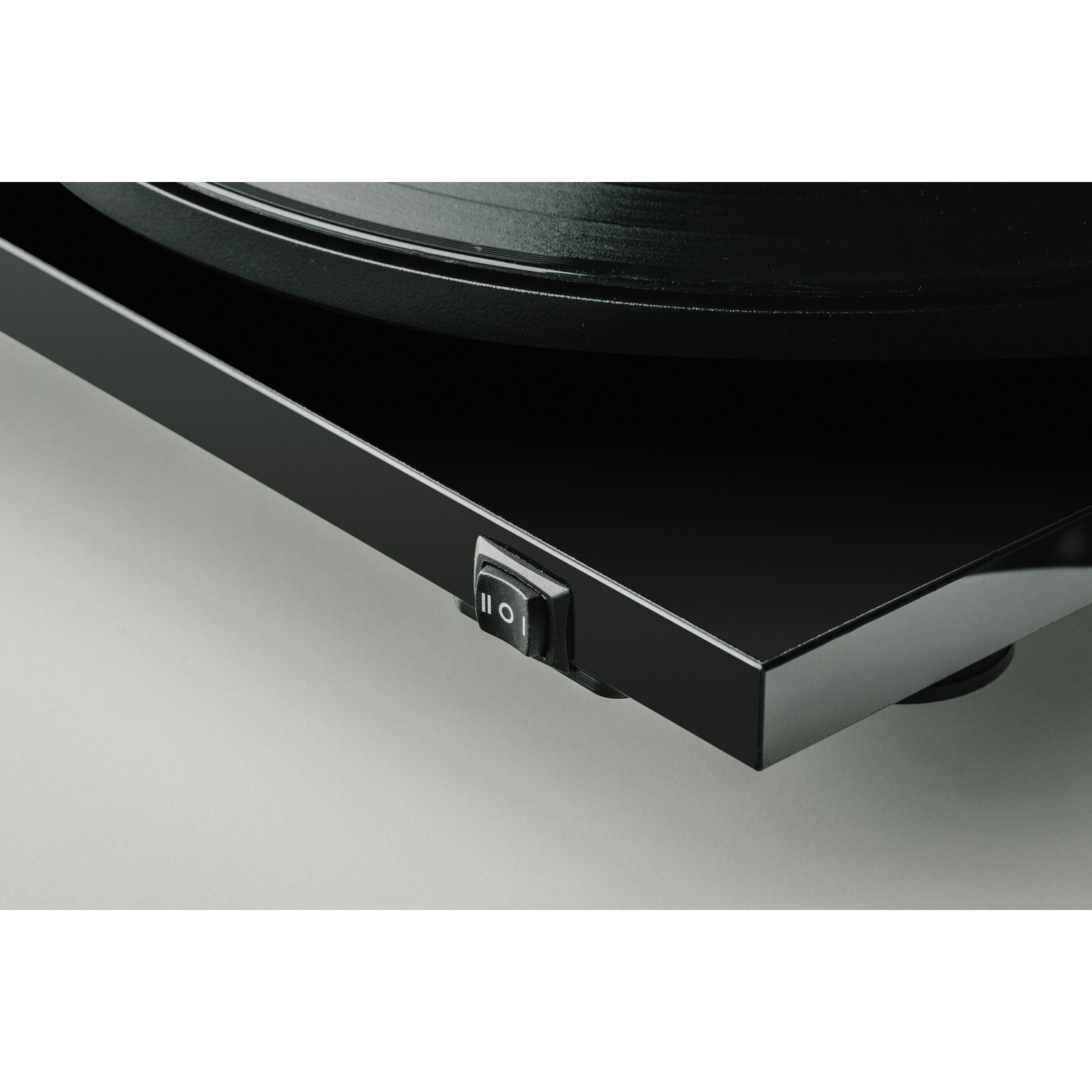 Giradischi nero con interruttore on/off e disco in vinile.