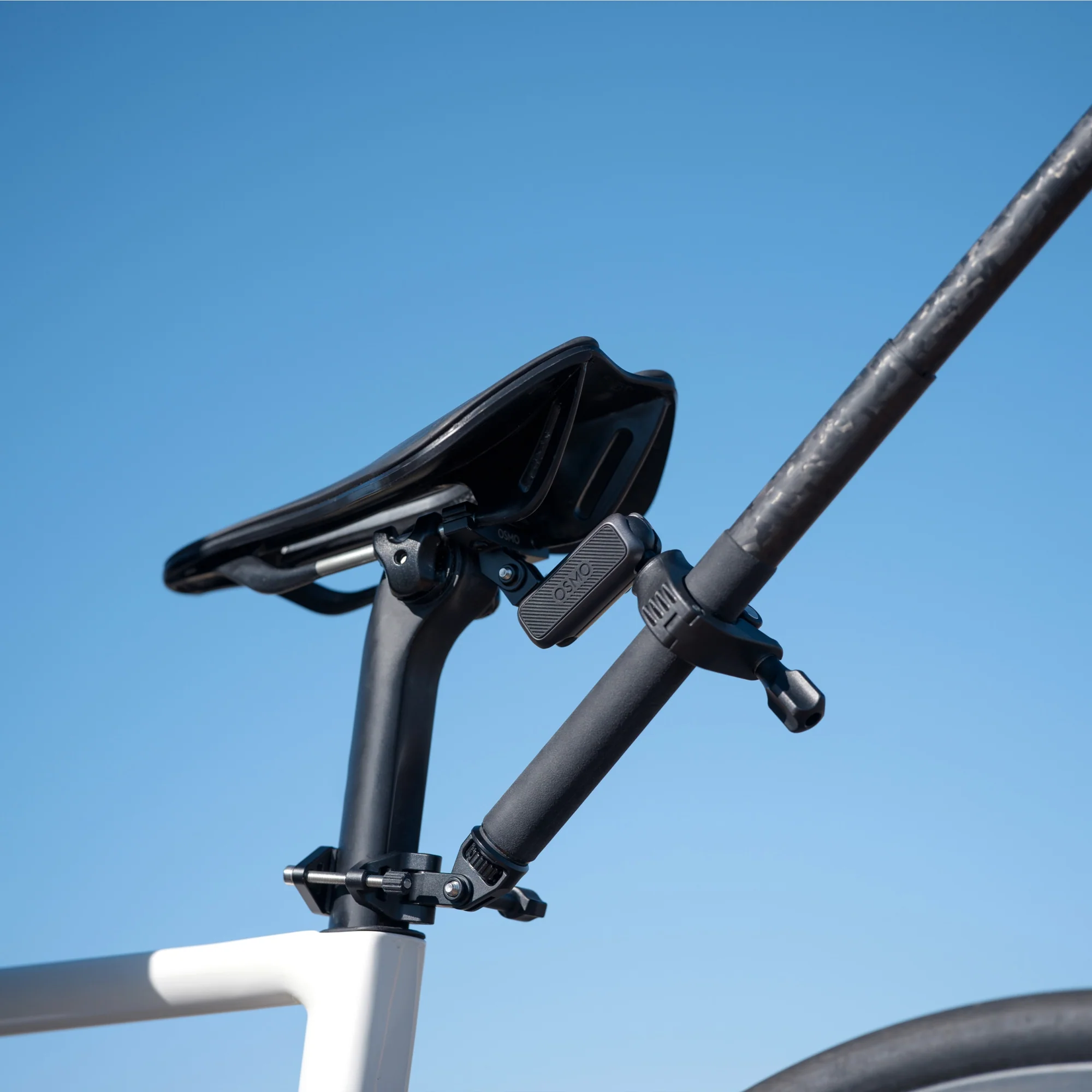 Zbliżenie sztycy siodełka rowerowego z akcesoriami na tle niebieskiego nieba.