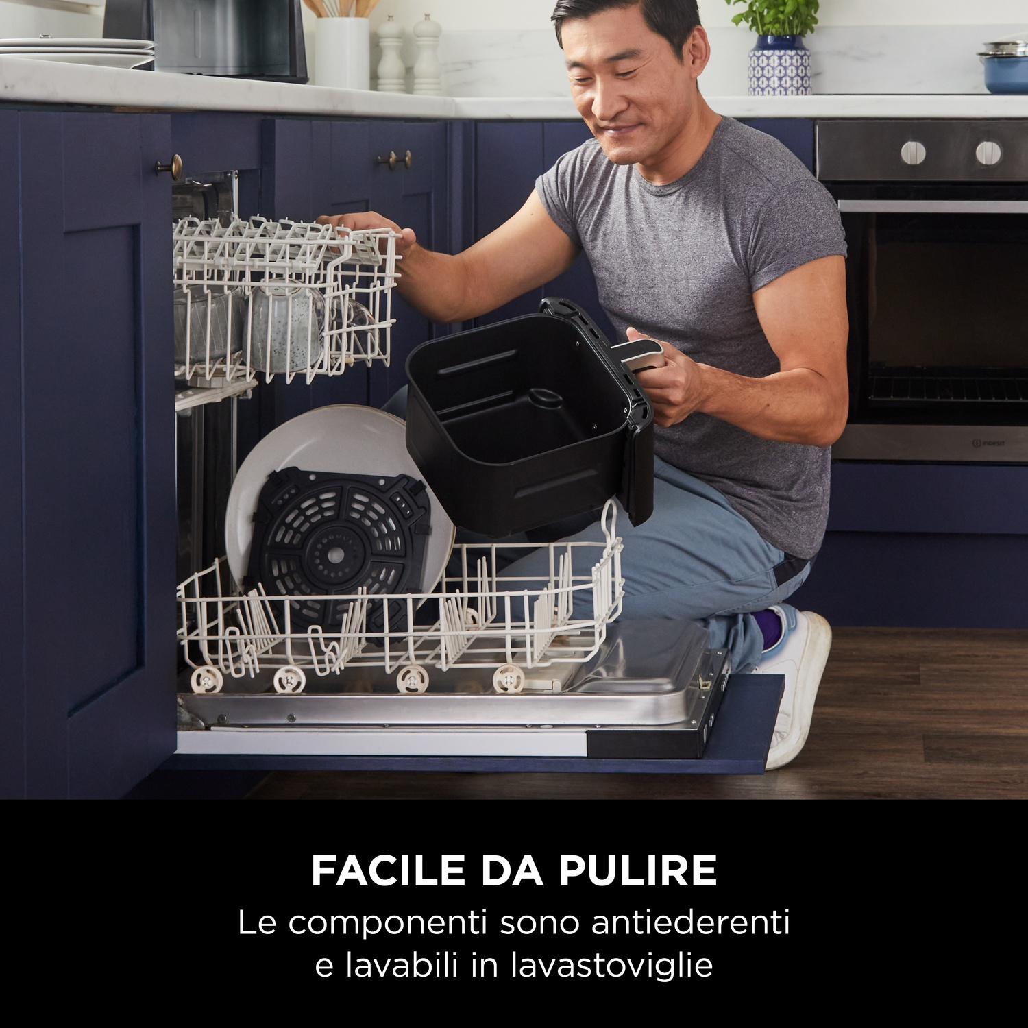 Uomo carica lavastoviglie. Un uomo mette parti di un apparecchio in una lavastoviglie aperta.