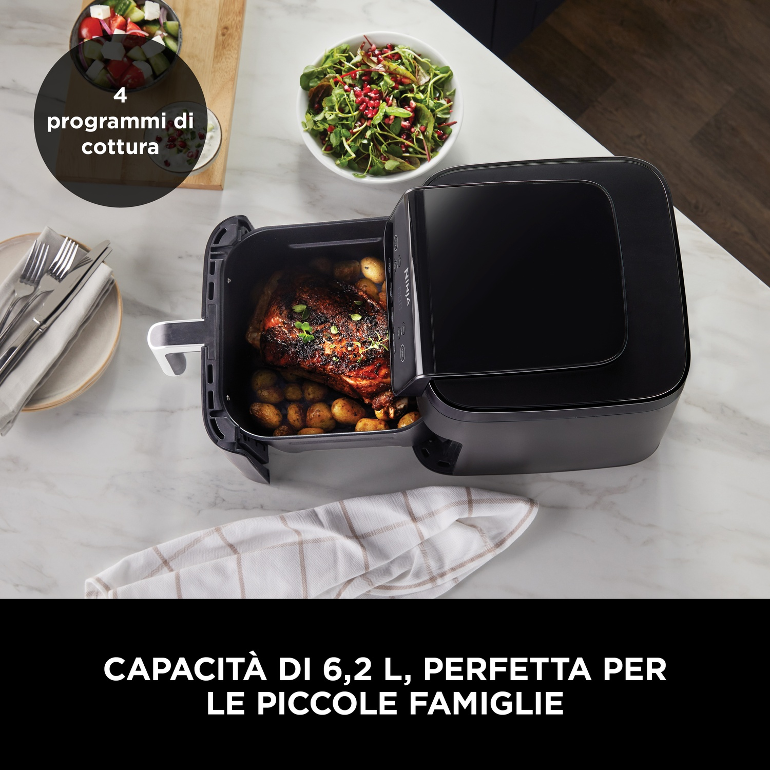 Una friggitrice ad aria nera con pollo arrosto e patate.