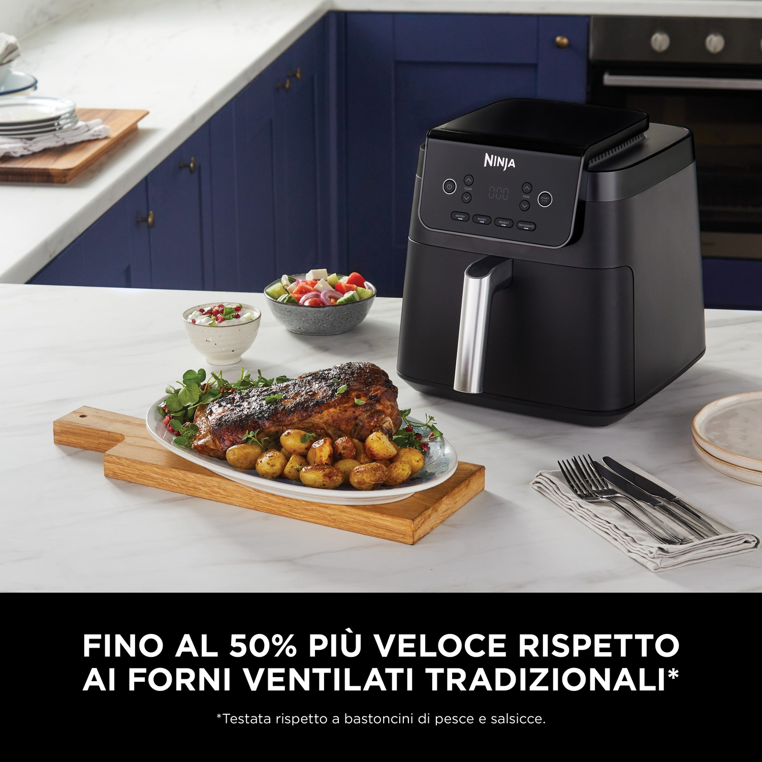 Una friggitrice ad aria Ninja nera accanto a un piatto di arrosto e patate.