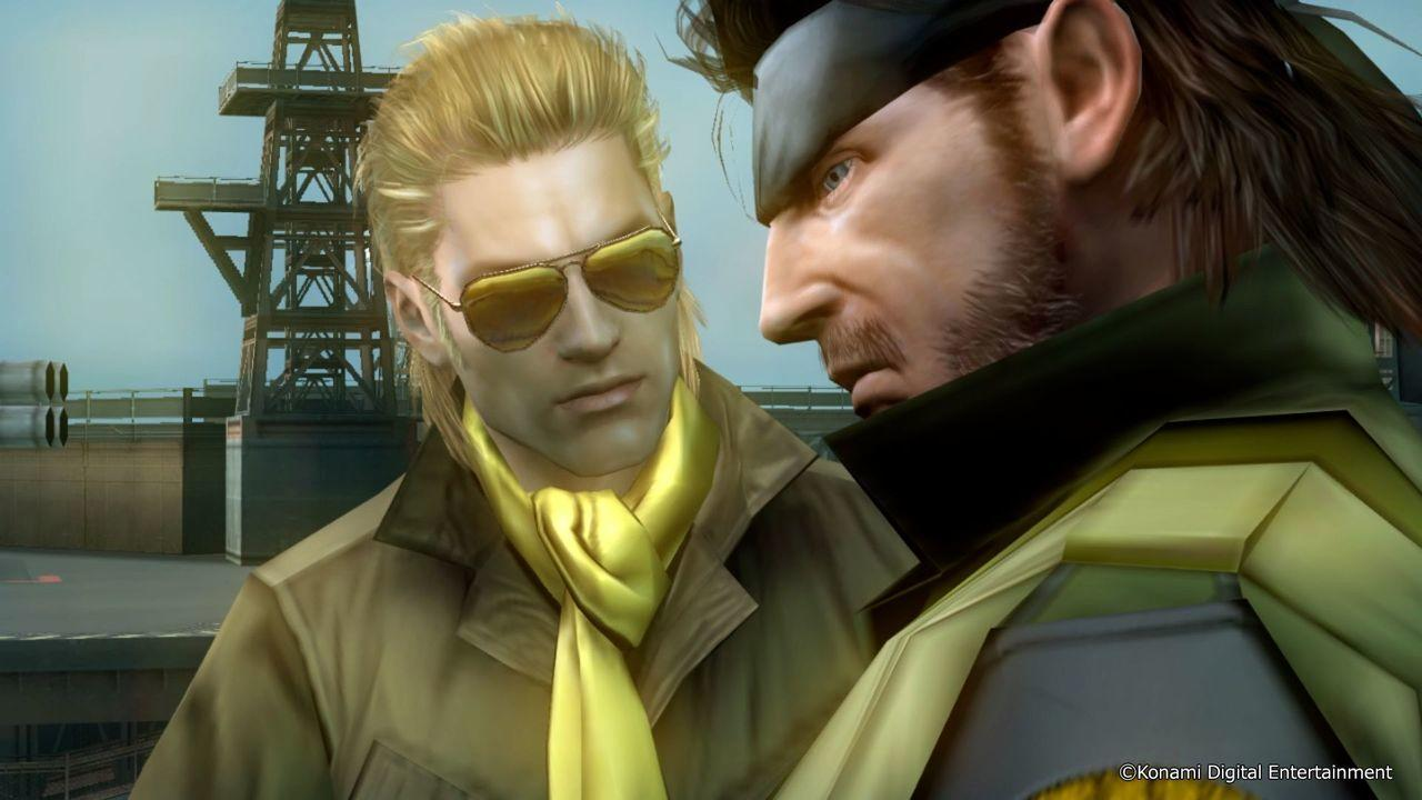 Zwei Männer sprechen sich an. Einer trägt eine gelbe Krawatte und Sonnenbrille.