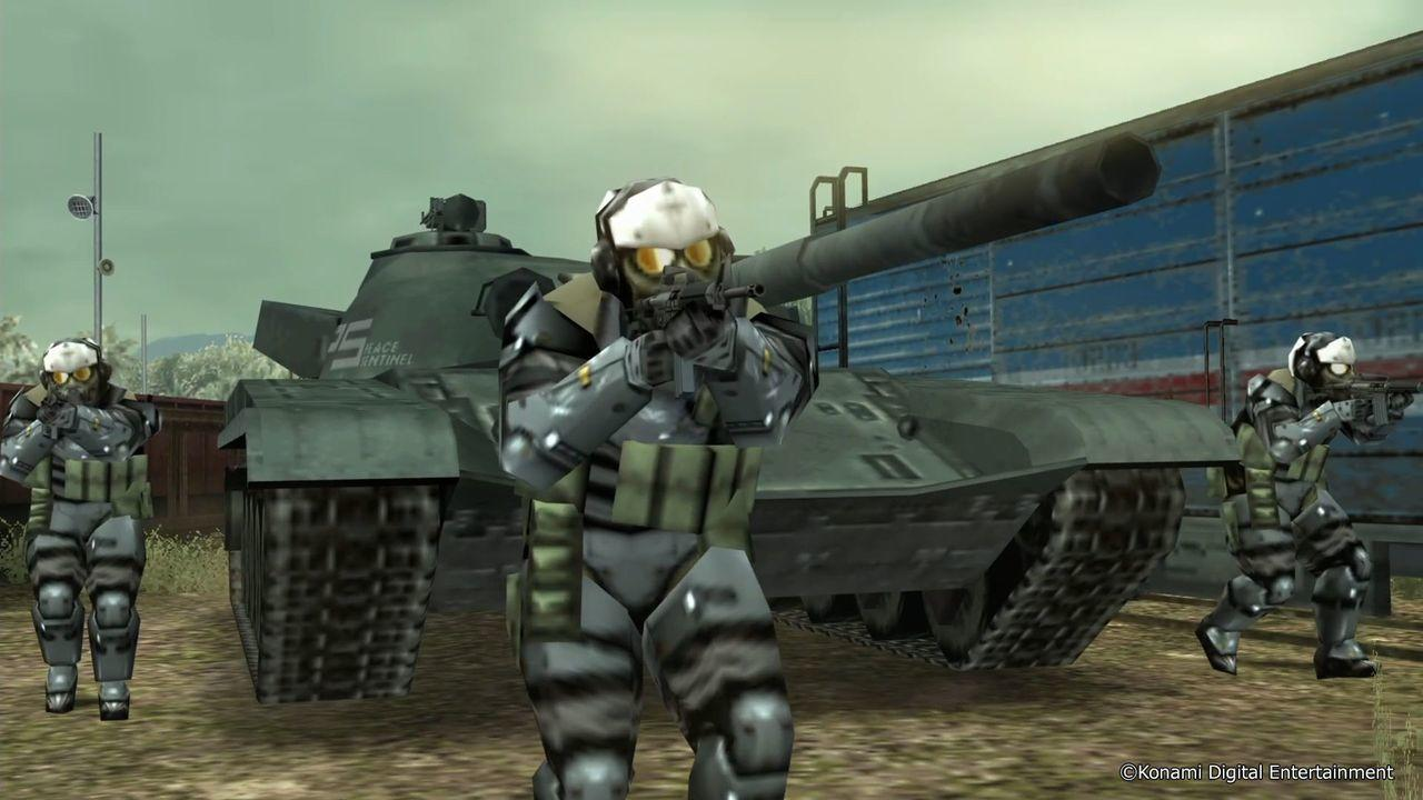 Drei Soldaten in Rüstung mit Gasmasken und Gewehren stehen vor einem Panzer und einem Güterwaggon.