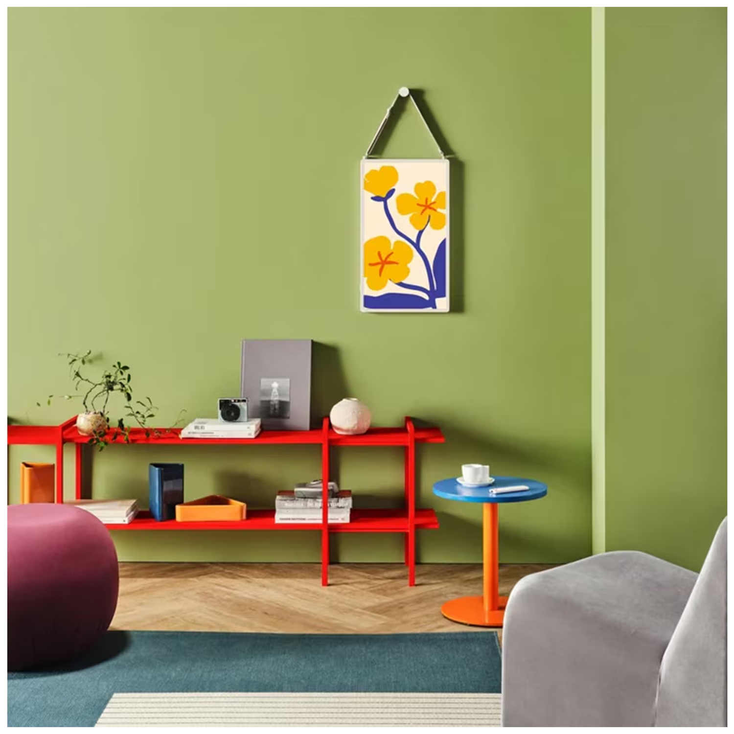 A living room with green walls, a red shelf, a purple ottoman, and a small blue table.