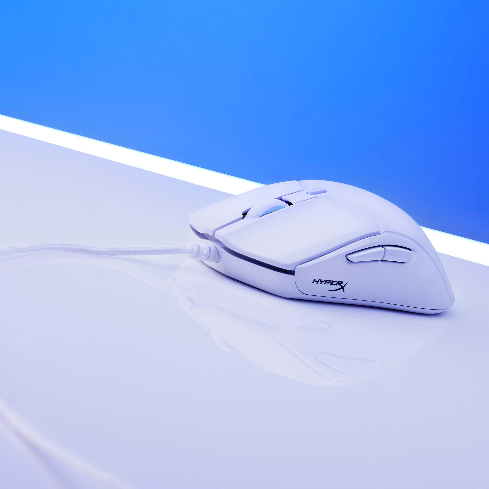 Biała mysz gamingowa HyperX leży na gładkiej, białej powierzchni.
