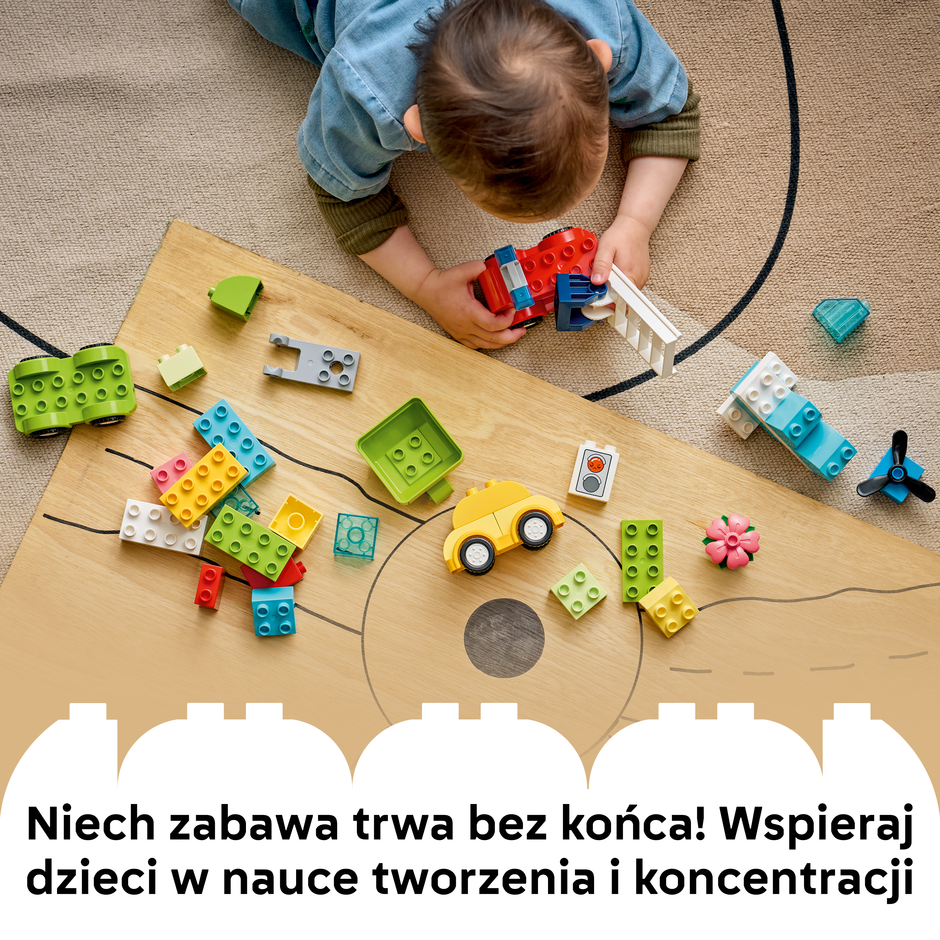 Maluch bawi się kolorowymi klockami, samochodem, samolotem i kwiatkiem.