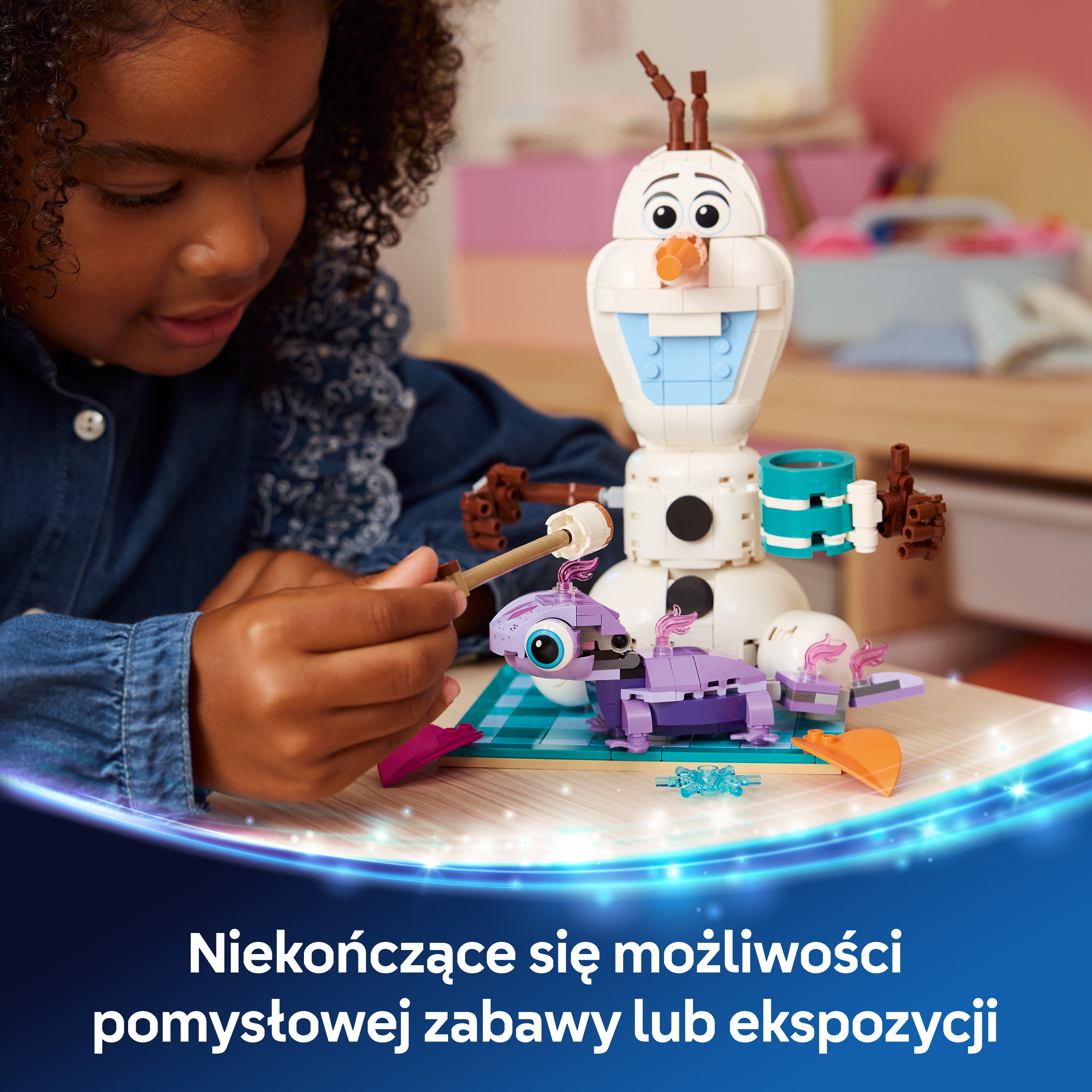 Dziewczynka buduje Olafa z Lego i fioletowe stworzenie na stole.