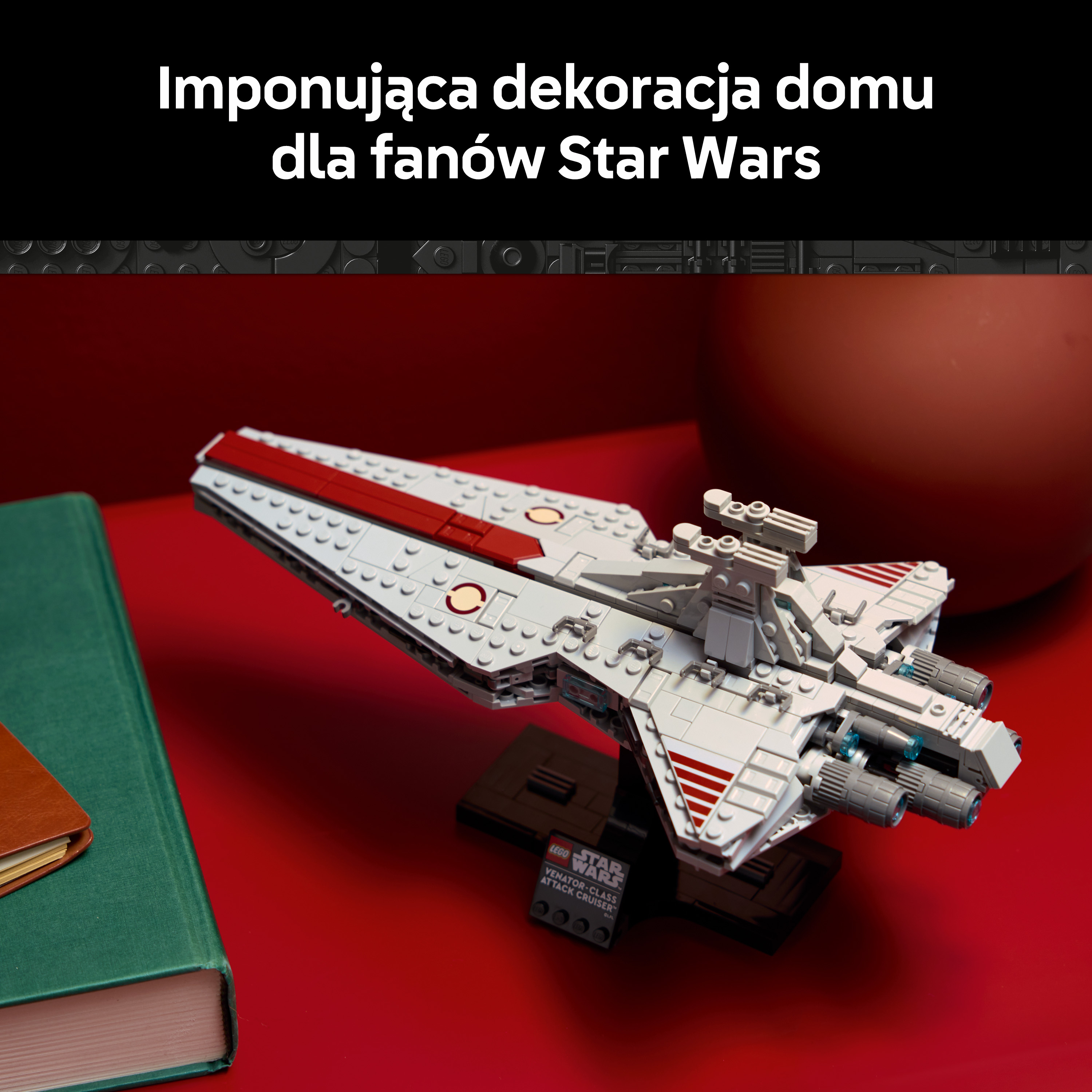 Model statku kosmicznego Lego na czerwonym tle obok książki.