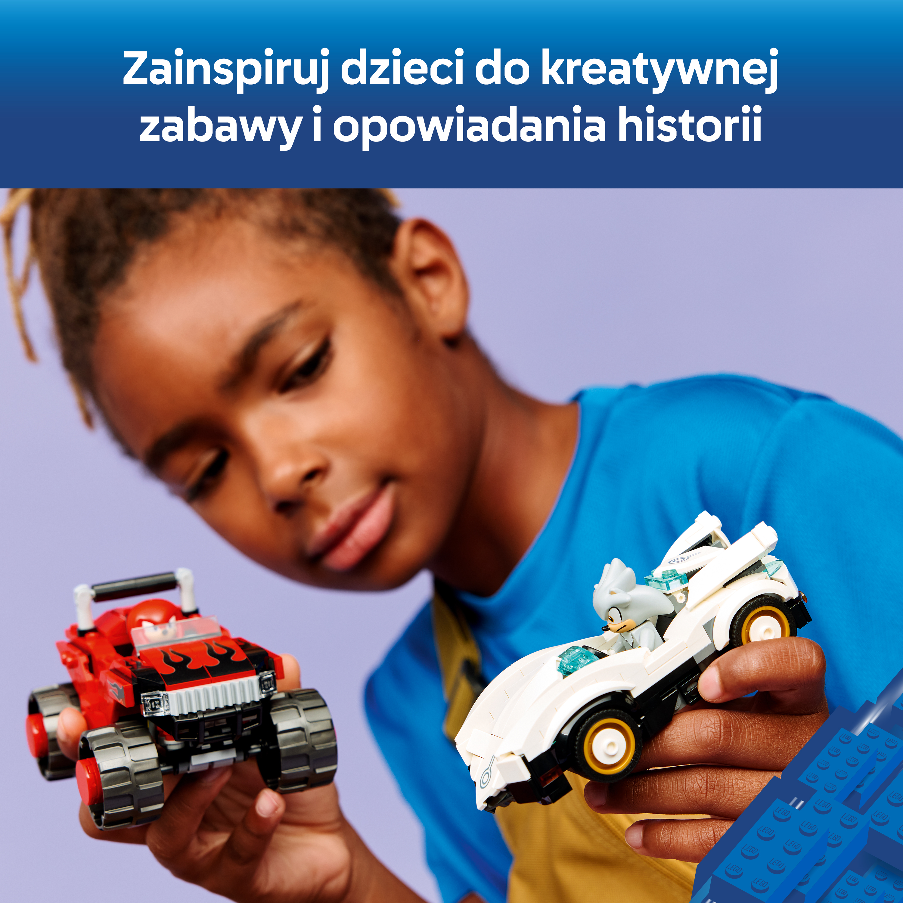 Chłopiec trzyma dwa samochody LEGO: czerwony i biały. Tło jest fioletowe.