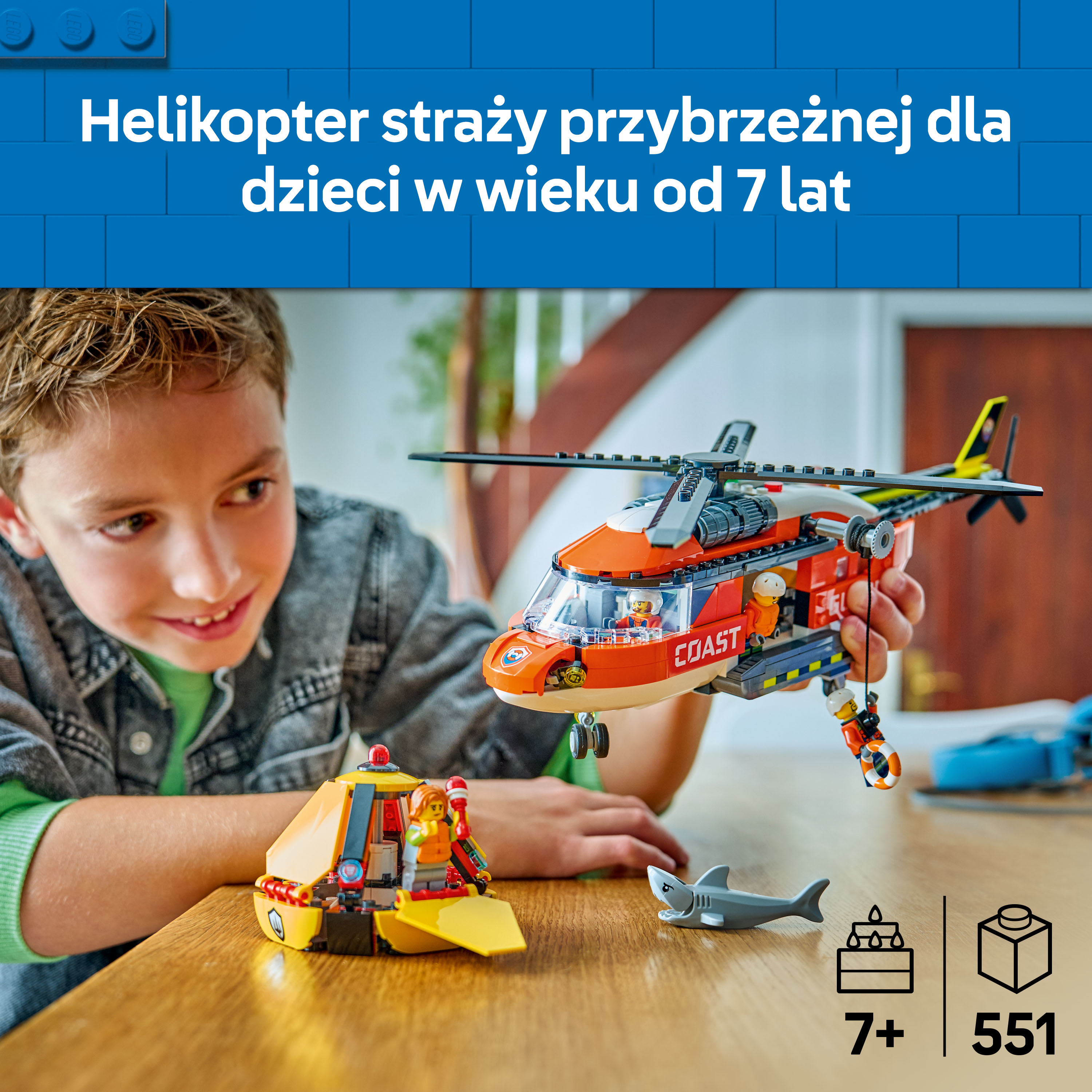 Chłopiec bawi się czerwonym helikopterem ratunkowym Lego i małą żółtą łódką.