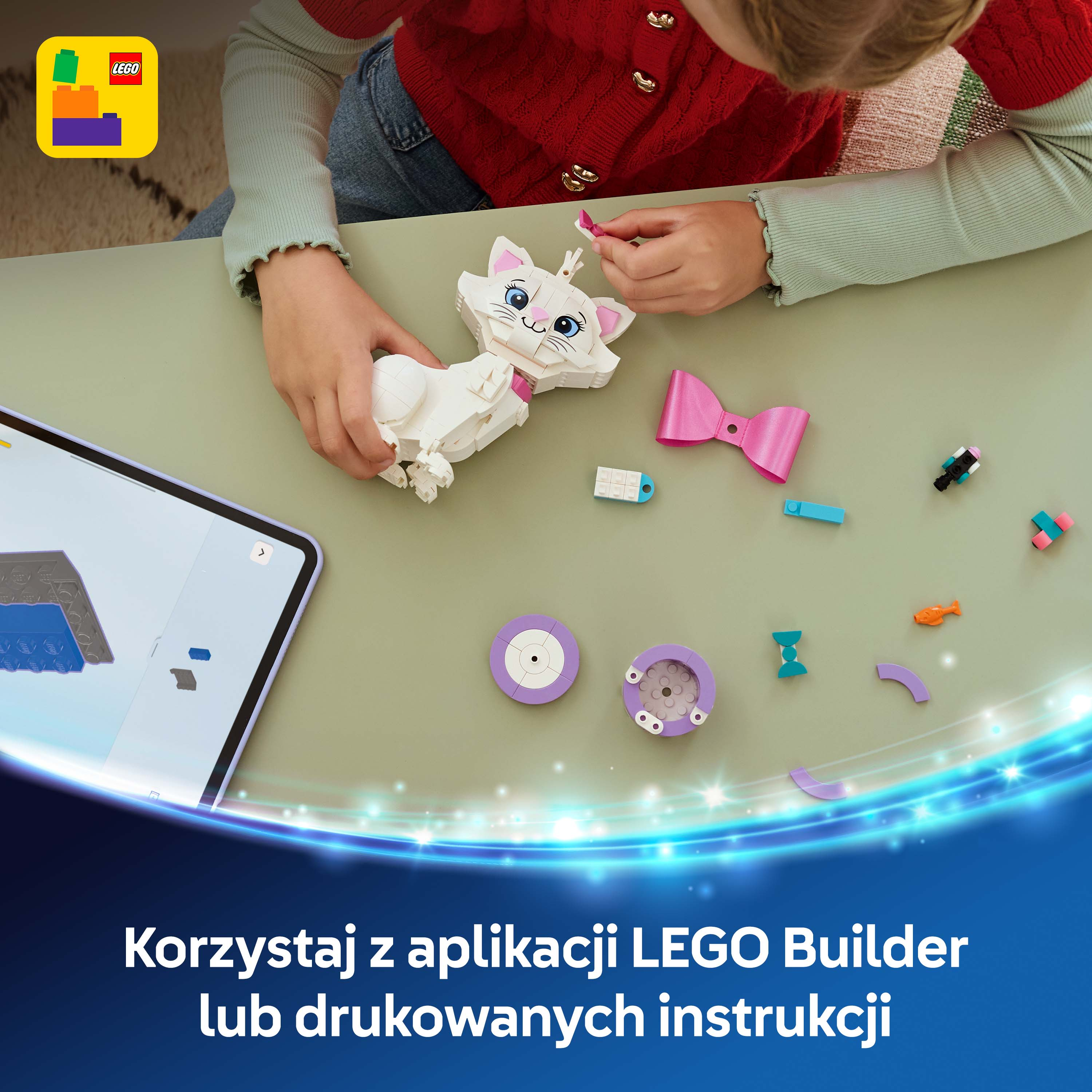 Dziecko buduje białego kota LEGO przy stole obok tabletu.