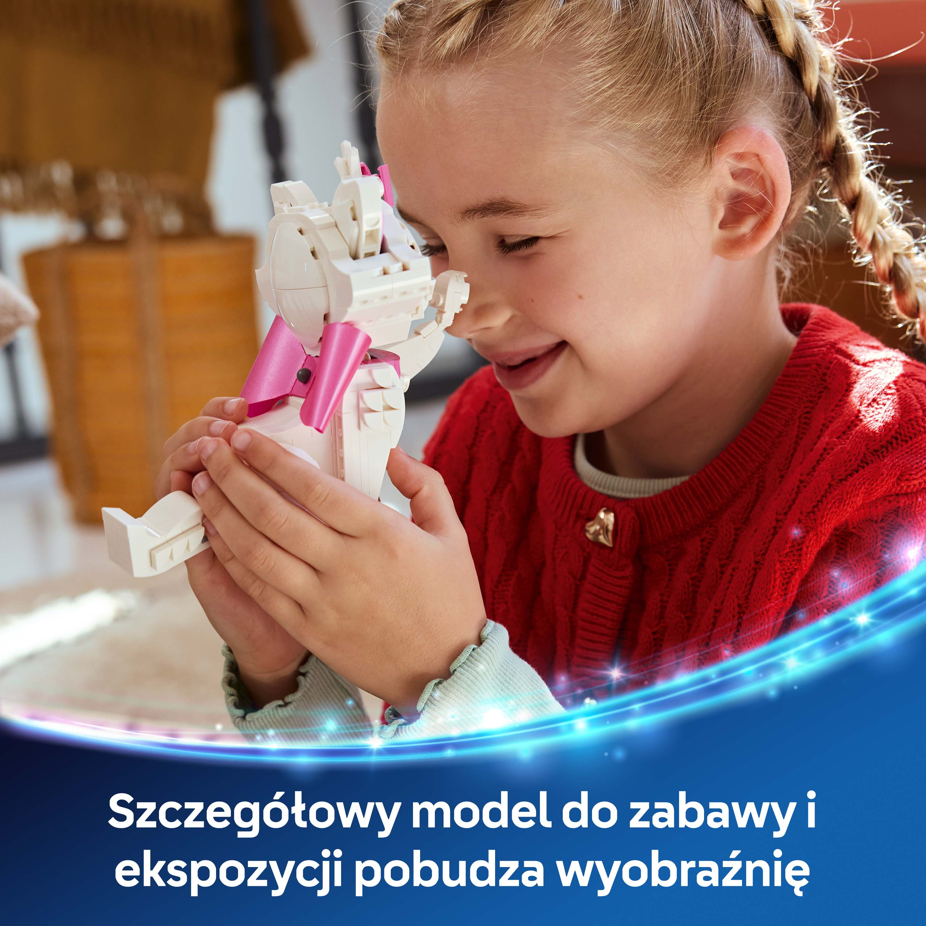 Dziewczynka z warkoczami trzyma biały model Lego z różową kokardką.
