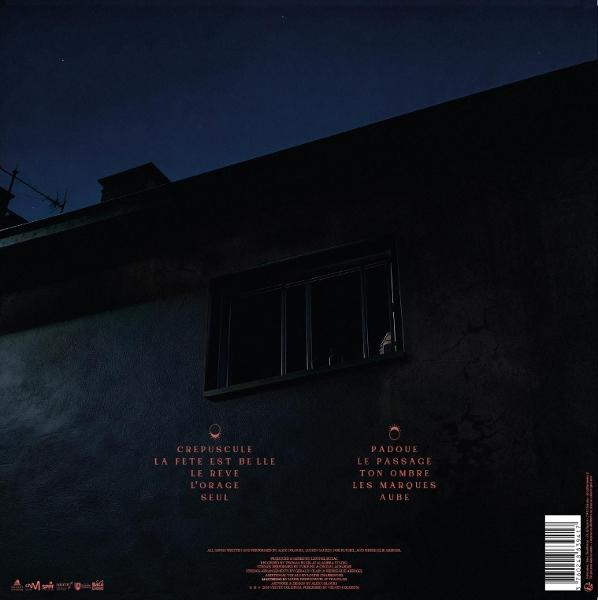 Dunkle Hauswand bei Nacht mit einem Fenster und Text.