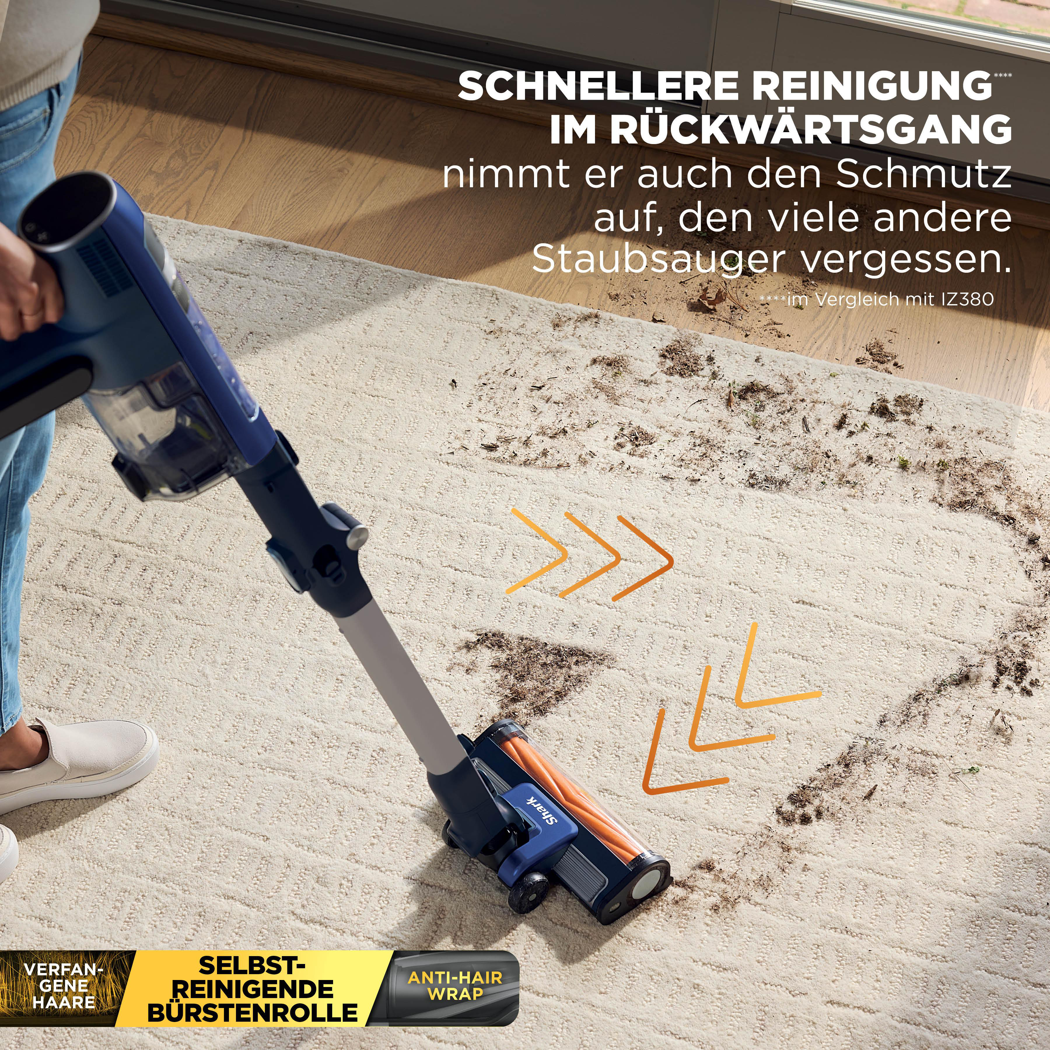 Ein blauer Staubsauger reinigt einen hellen Teppich von Schmutz und Haaren.