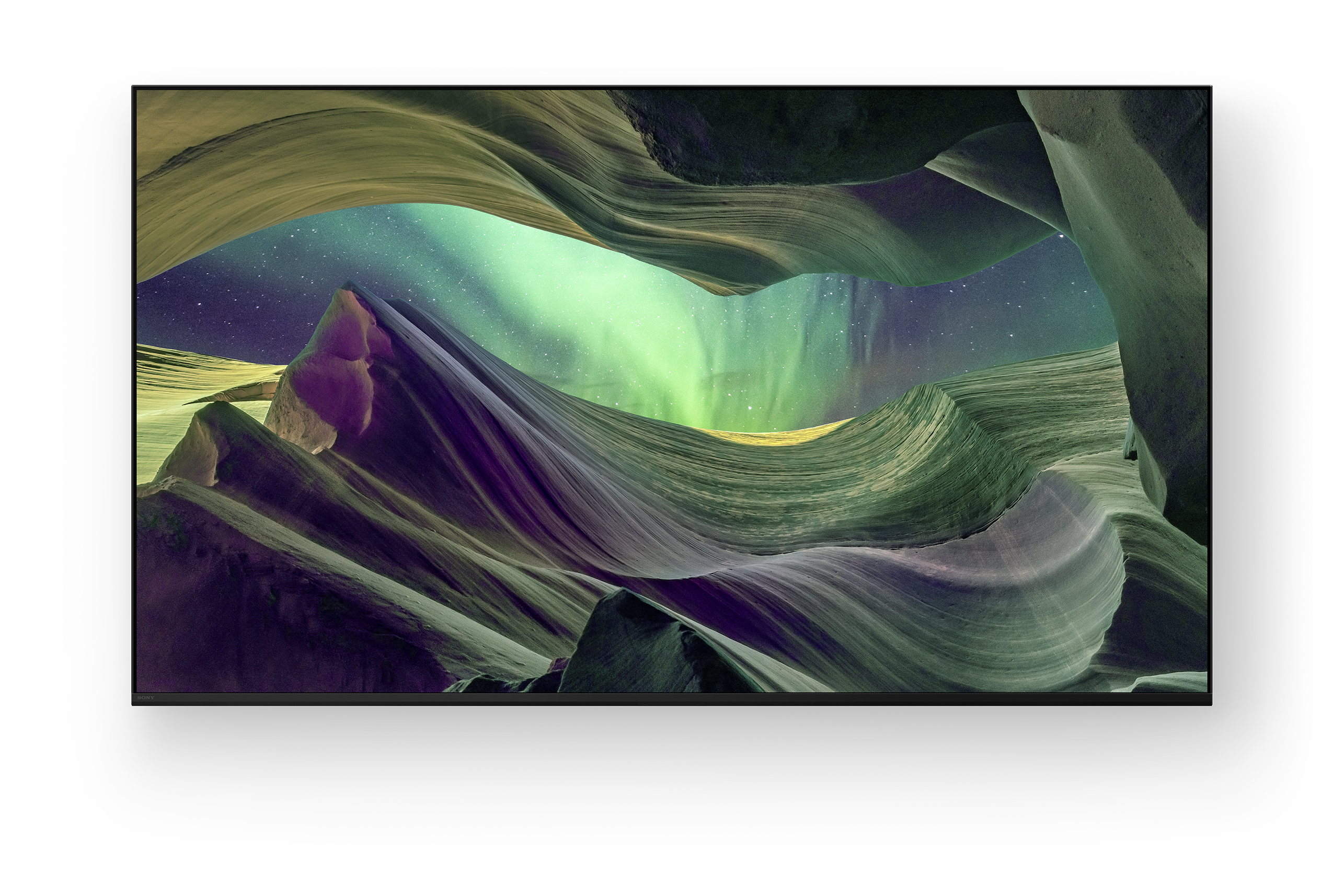 Wirujące formacje piaskowca pod gwiaździstym niebem z zieloną zorzą polarną.