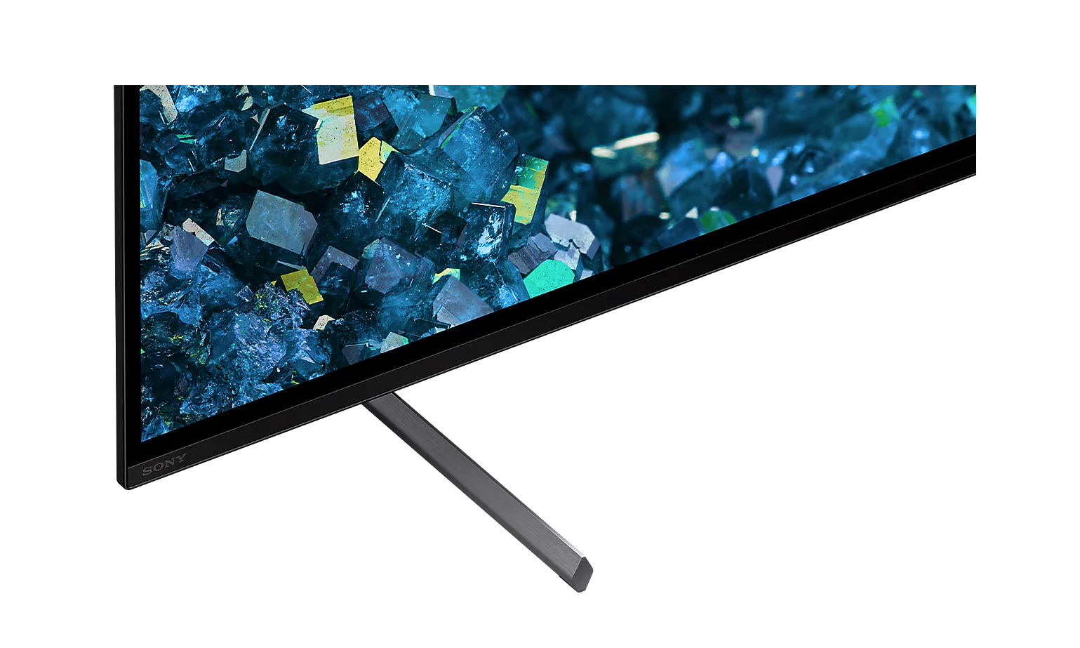 Zbliżenie ekranu telewizora Sony z abstrakcyjnymi kryształami w kolorze niebieskim i zielonym, z ciemnym stojakiem.