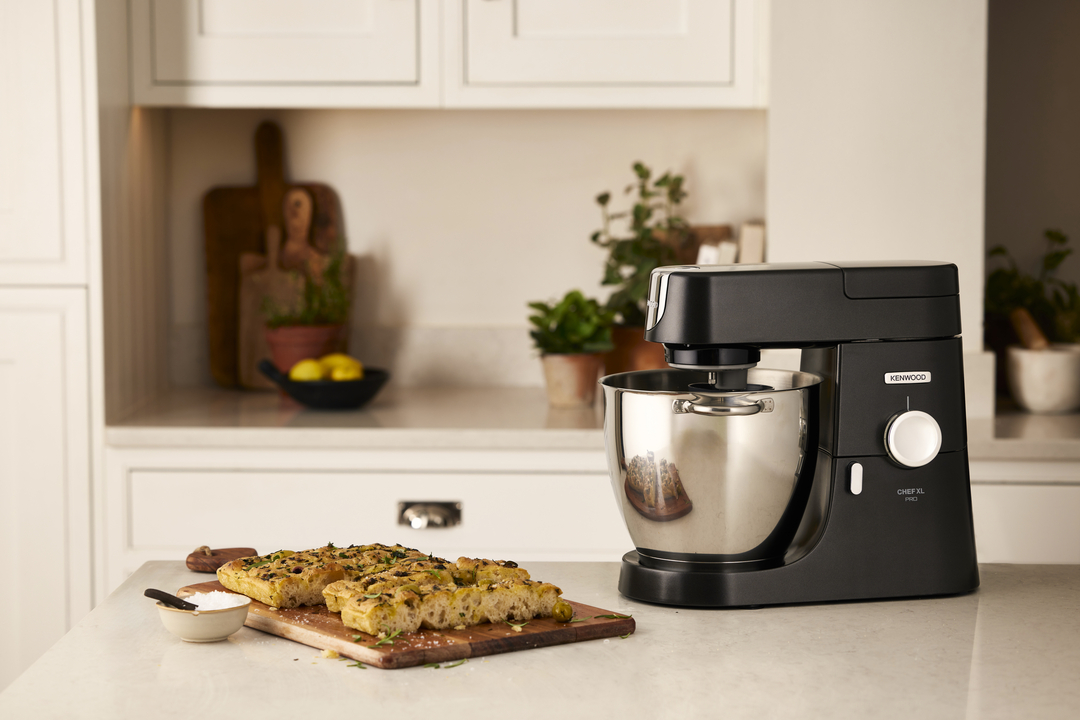 Ein schwarzer Kenwood Küchenmaschinen-Standmixer steht neben frisch gebackenem Focaccia-Brot.