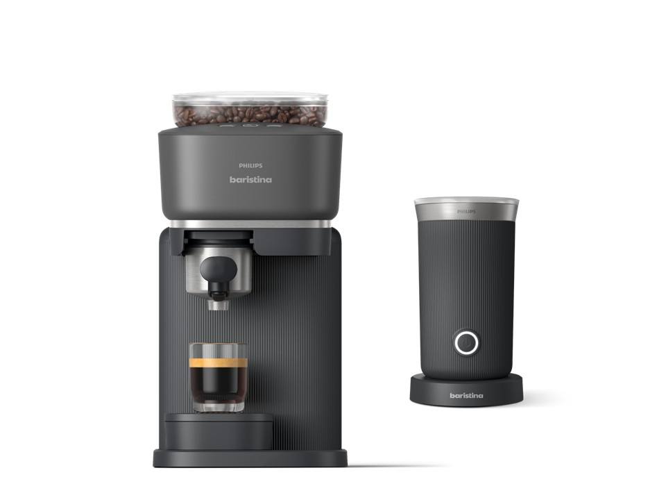Cafetera oscura con depósito de granos y taza de espresso, junto a un espumador de leche.