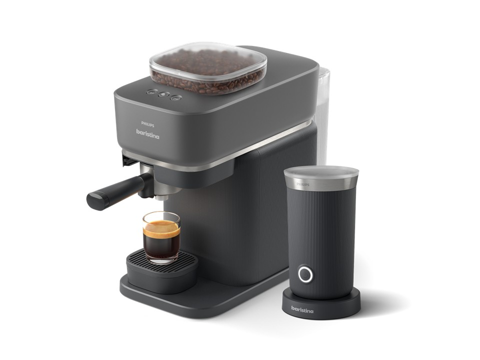 Una cafetera oscura con un vaso de espresso y un espumador de leche.