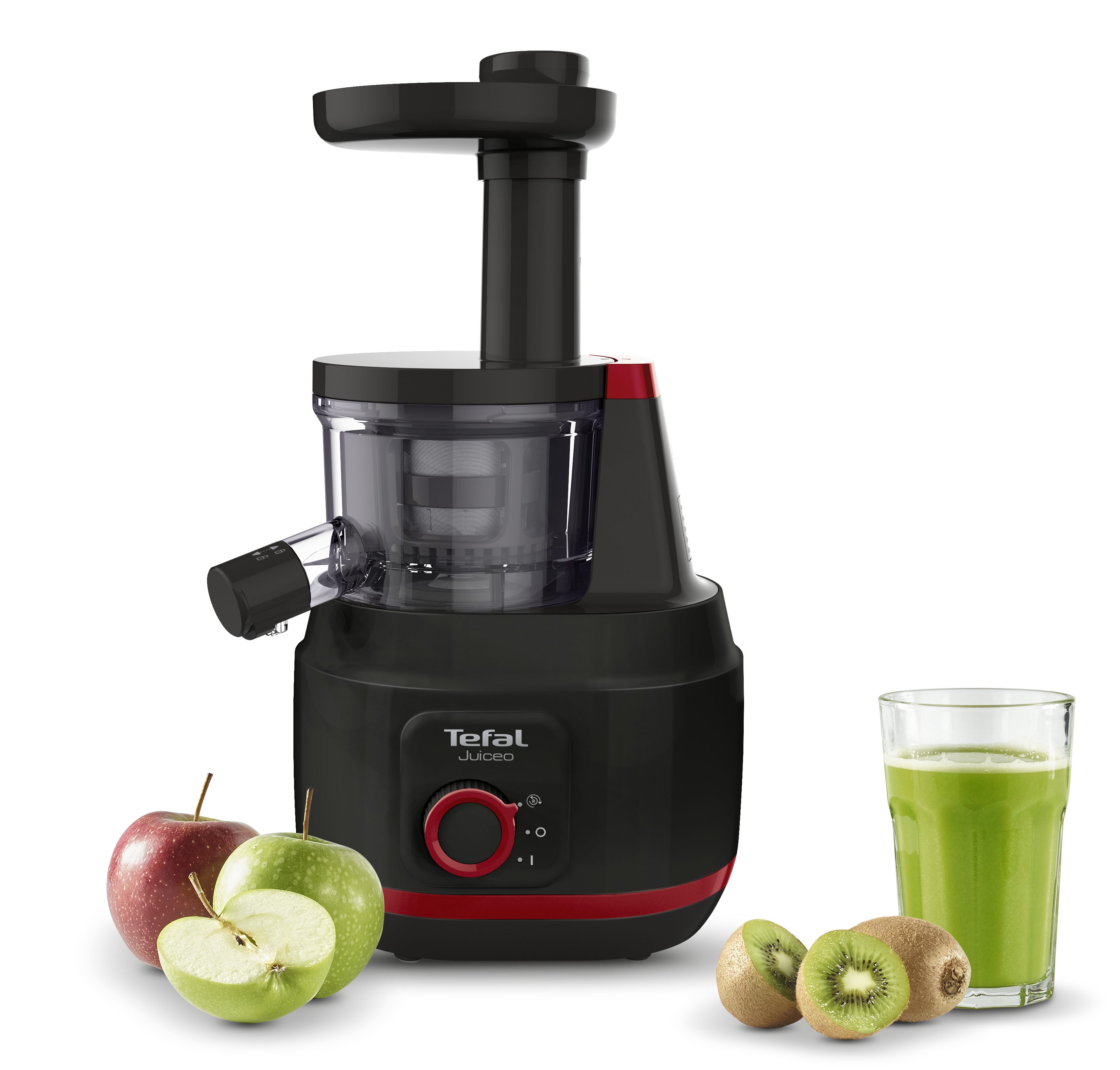 Egy fekete Tefal Juiced gyümölcscentrifuga almákkal és kivivel, egy pohár lé mellett.