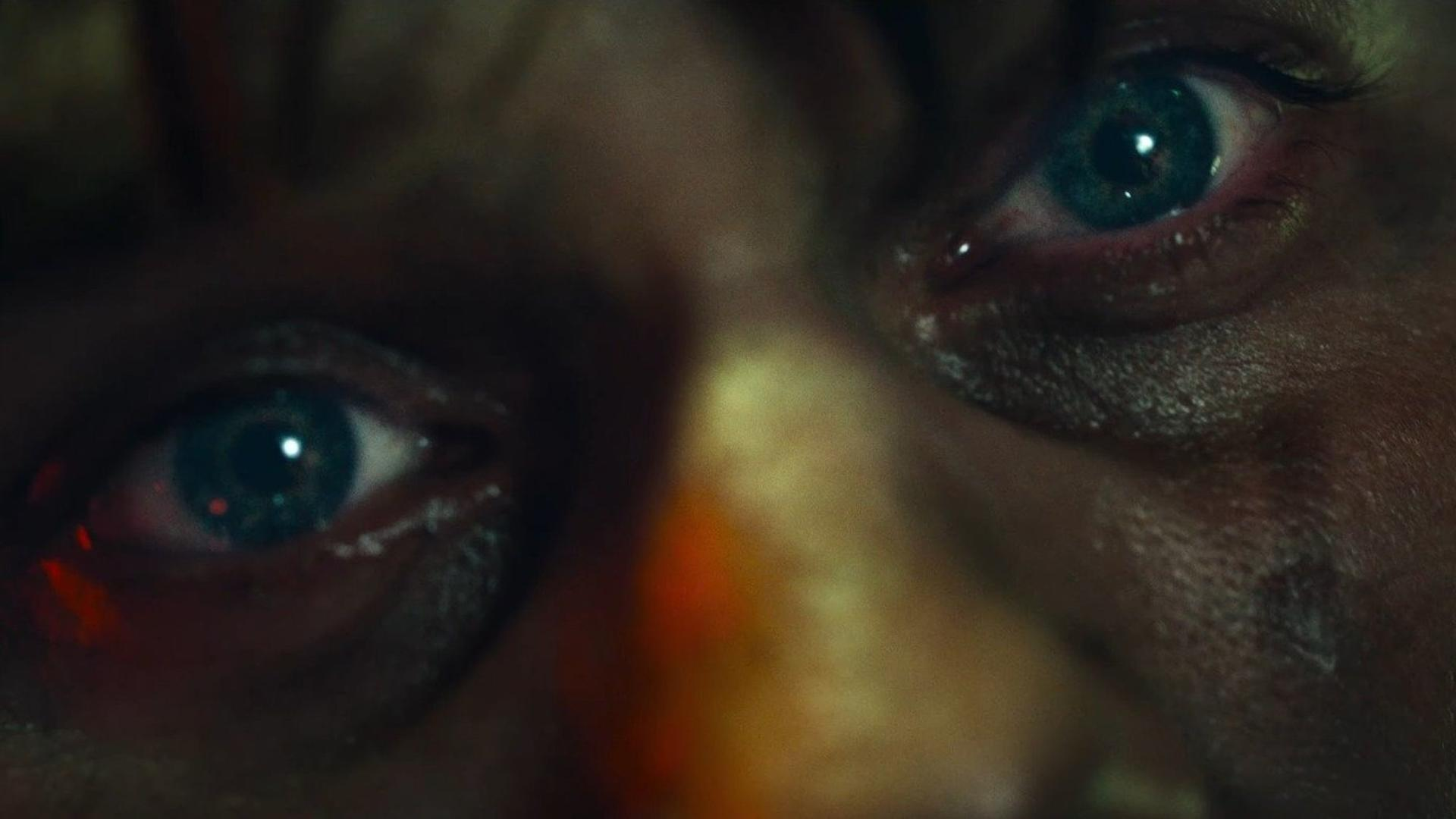 Nahaufnahme von zwei Augen mit blauen Iris und Lichtern. Dunkle Haut.