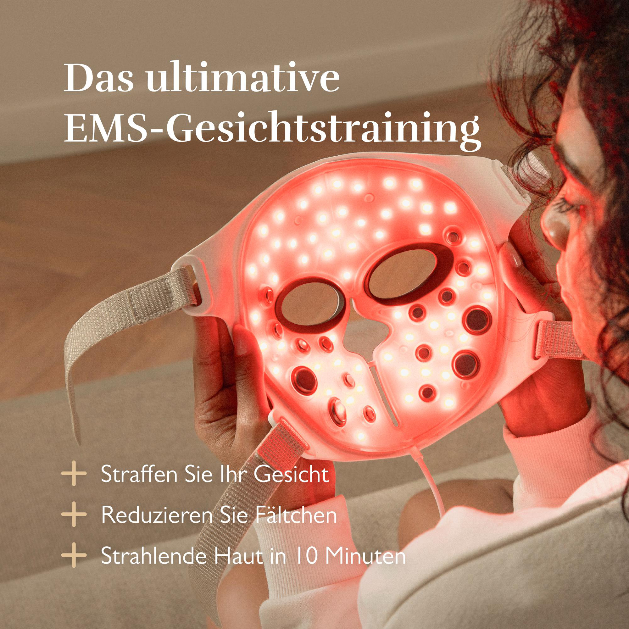 Eine Frau benutzt eine rot leuchtende EMS-Gesichtsmaske.