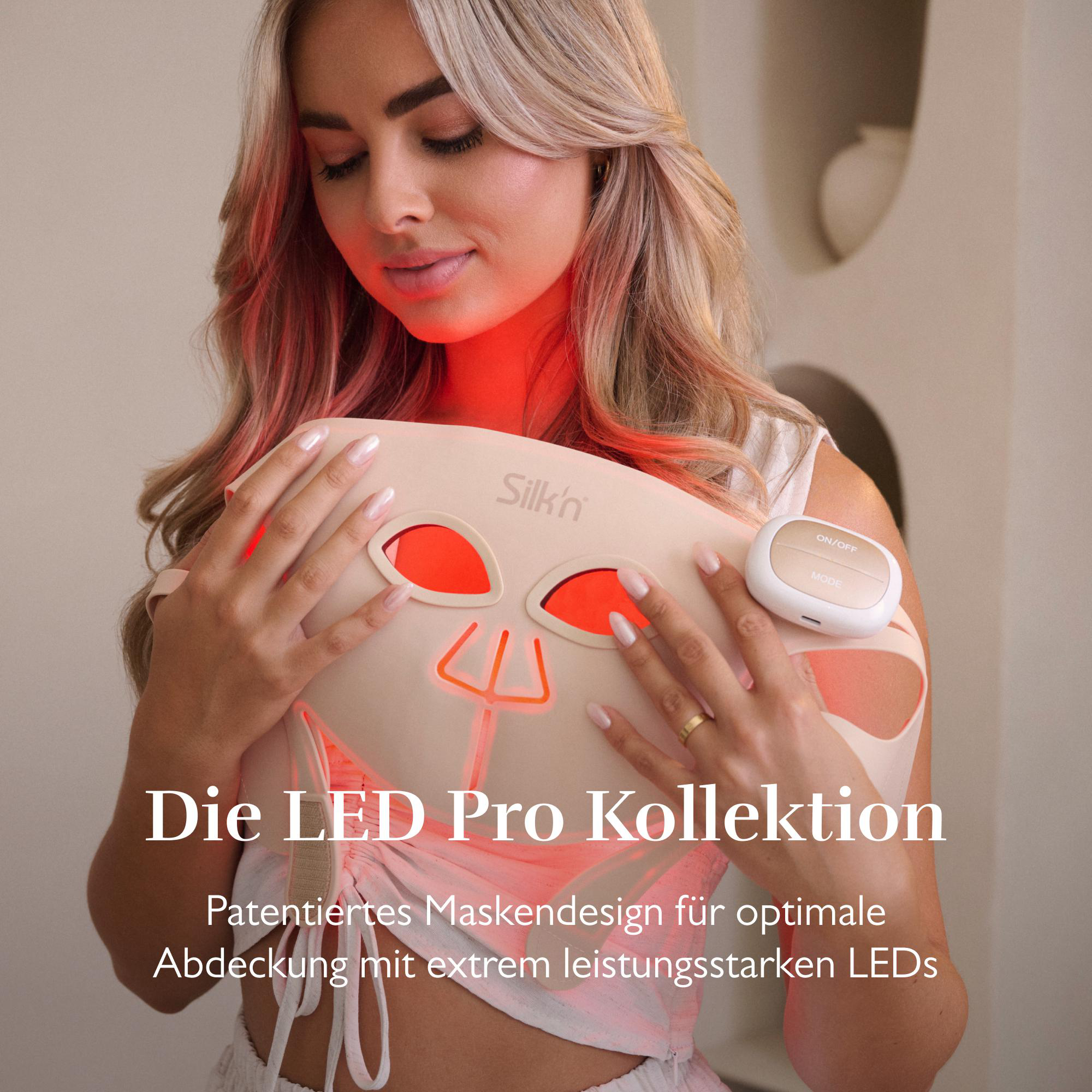 Frau hält eine Silk'n LED-Maske mit roten Lichtern und Bedienelement.