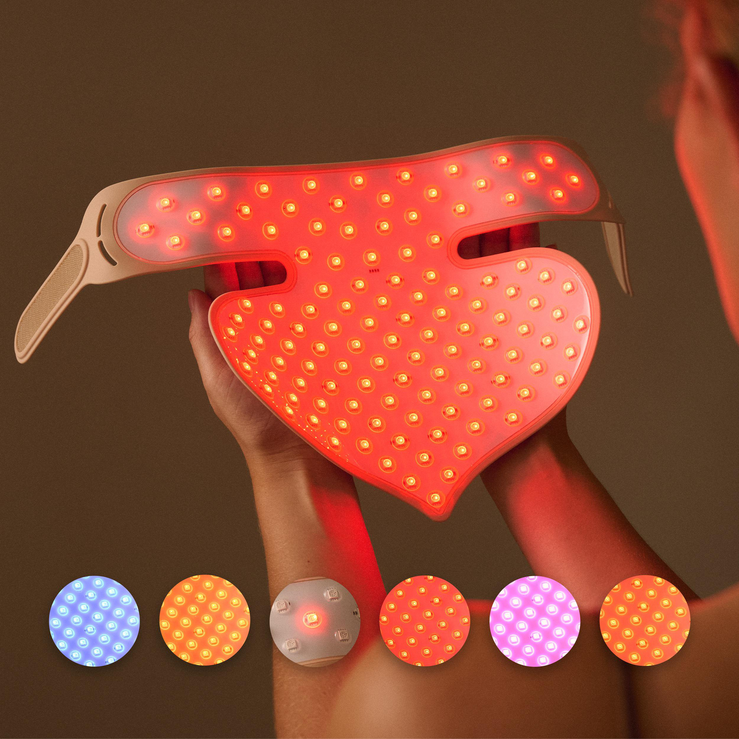 Ein Herzförmiges Gerät mit roten LEDs wird von Händen gehalten. Daneben sind Kreise mit blauen, orangen und lila Lichtern.