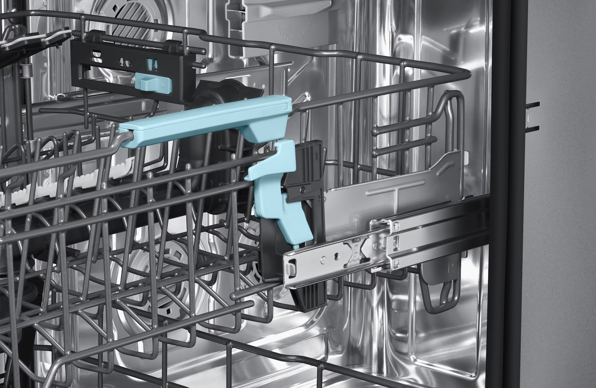 Widok wnętrza zmywarki z niebieskim i czarnym mechanizmem kosza.