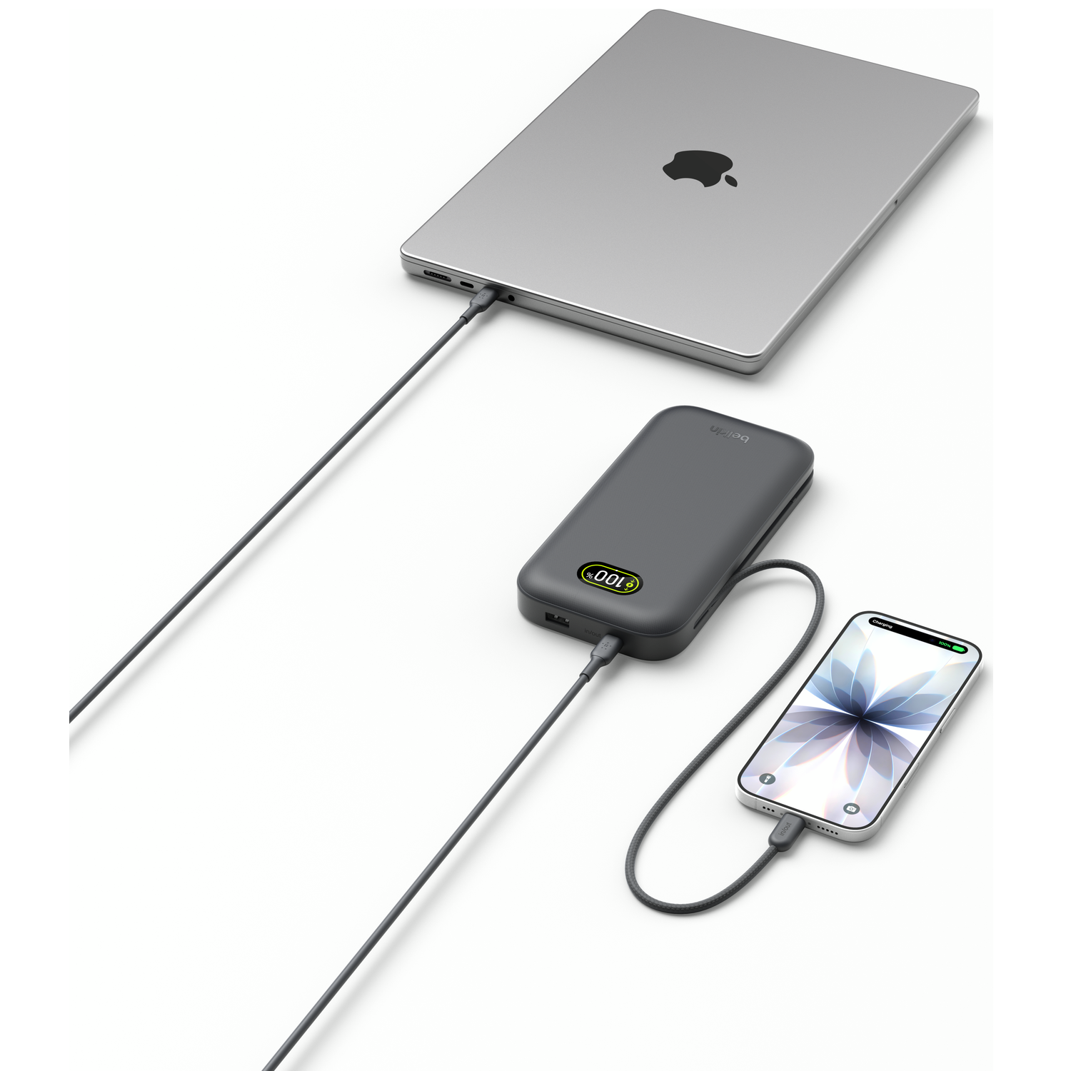 A gray MacBook, a power bank, and a smartphone are connected by cables.