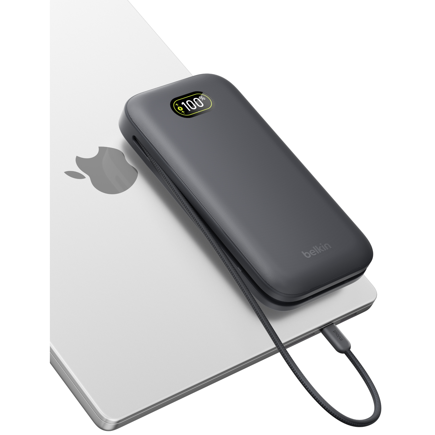 A gray charging cable connects a MacBook to a dark power bank device.