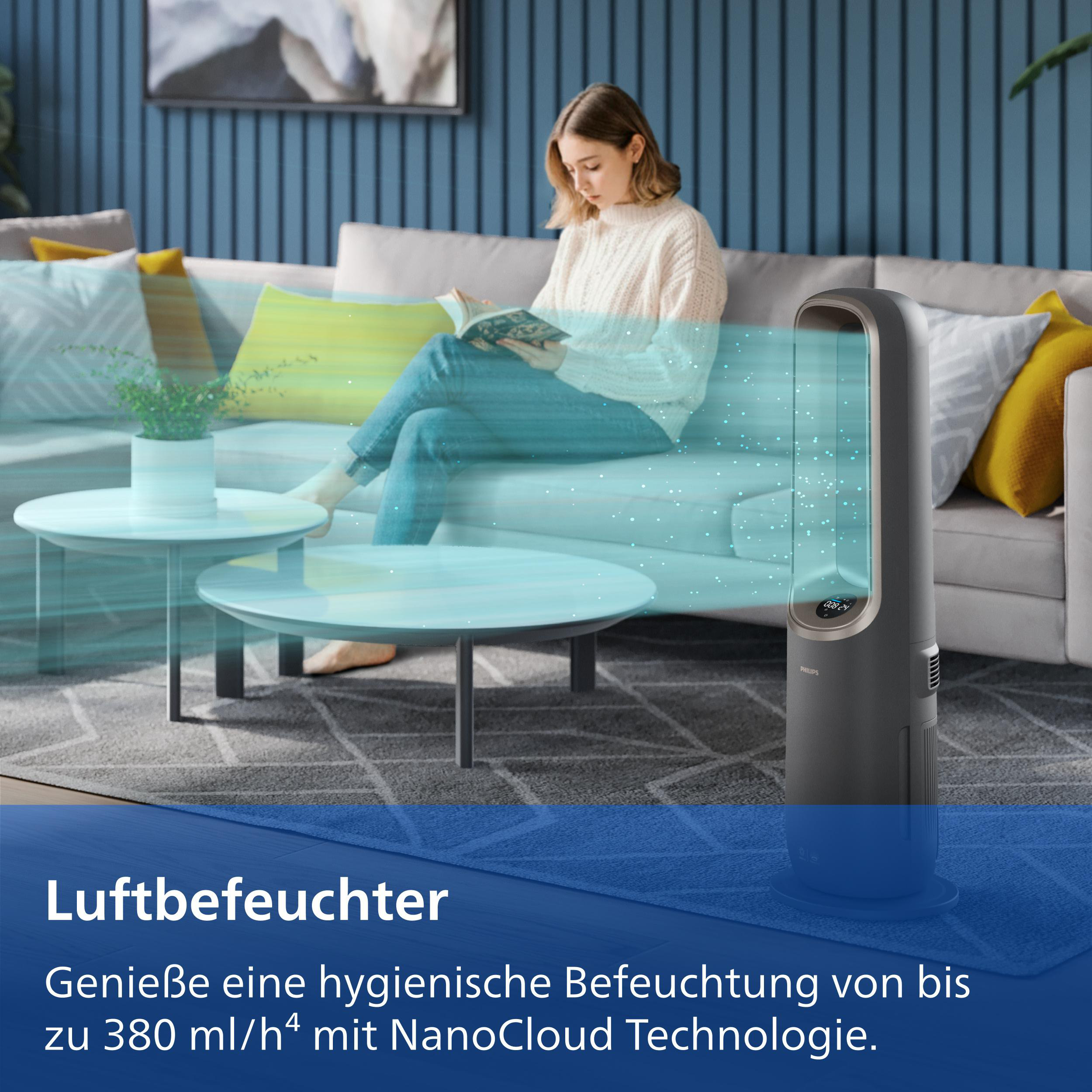 Eine Frau liest auf einem Sofa, neben einem Luftbefeuchter, der Nebel ausstößt.