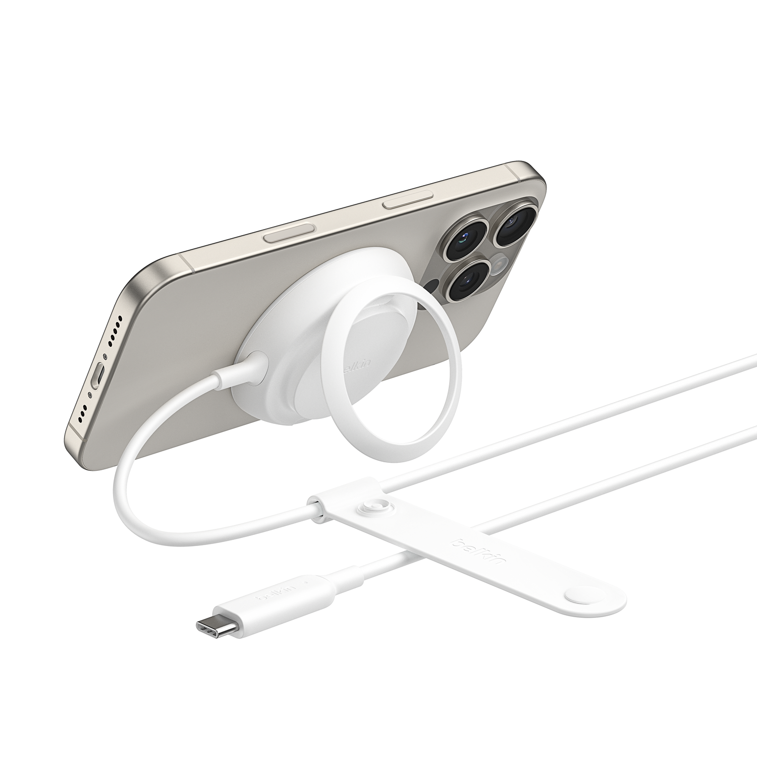 A white MagSafe charger with a ring attached to a silver iPhone.