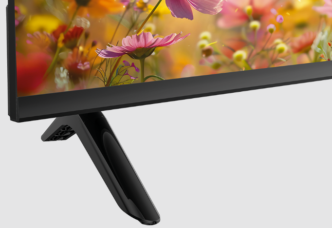 Ein schwarzer Fernseherfuß vor einem bunten Blumenhintergrund.