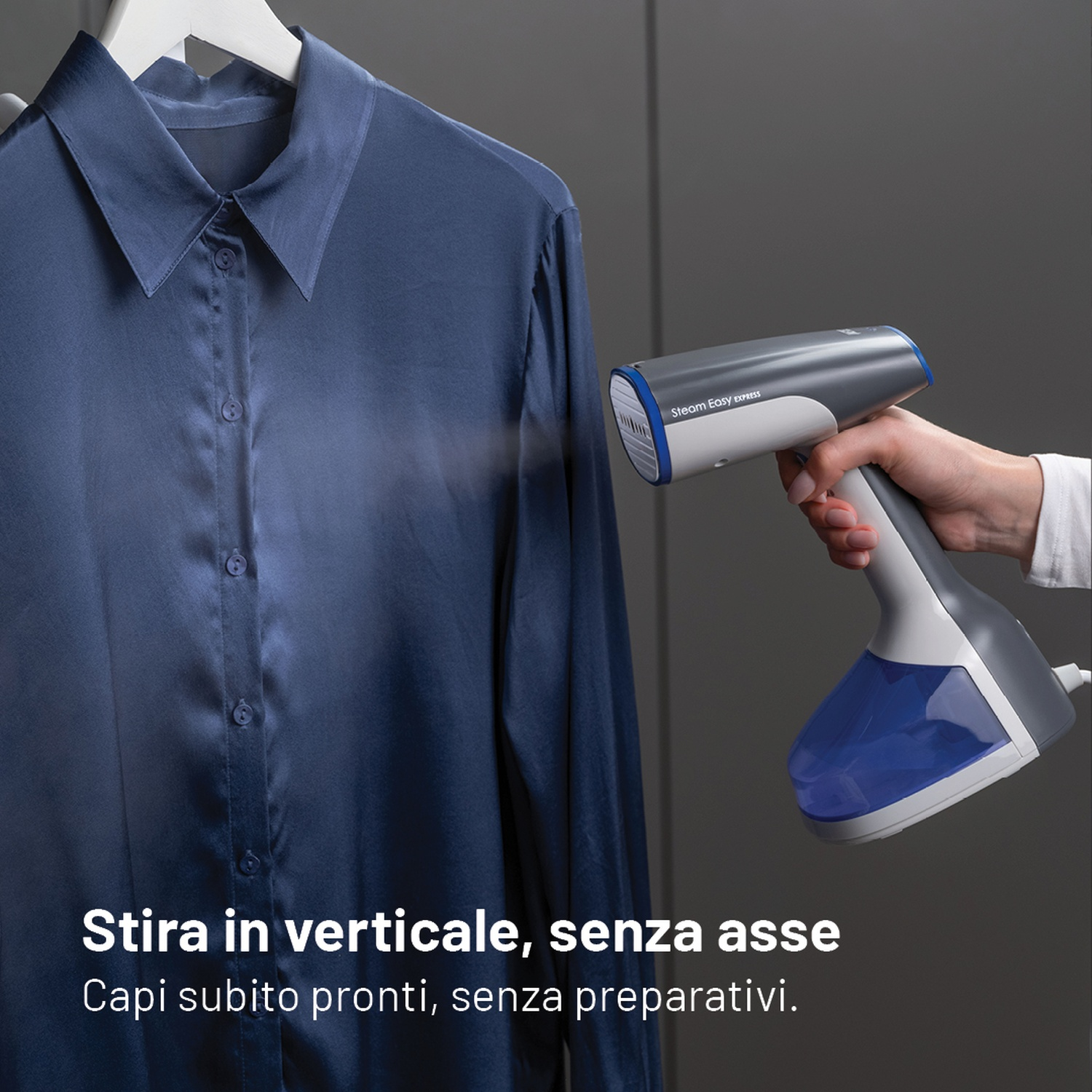 Un ferro da stiro a vapore portatile stira una camicia blu.
